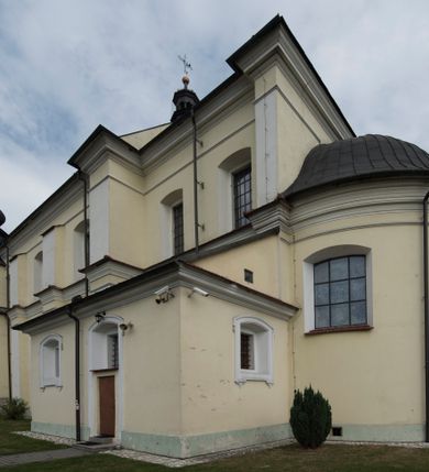 Zdjęcie nr 15: Kościół jest położony w centrum wsi, na wschód od głównej drogi, na placu otoczonym kamiennym murem przykrytym dachówką, z kilkoma drzewami. Wejście na plac przykościelny prowadzi przez szerokie schody i bramę od zachodu i bramkę od północy. Kościół jest budowlą założoną na planie prostokąta, jednonawowy, trójprzęsłowy z węższym, dwuprzęsłowym prezbiterium z apsydą. Do nawy przylegają od zachodu i północy dwie kruchty na planie kwadratu i wieża w narożu południowo-zachodnim fasady. Do prezbiterium od północy jest dostawiona kaplica na rzucie prostokąta otwierająca się półkolistymi arkadami, a od południa zakrystia. 
Artykulacja ścian jest przeprowadzona za pomocą zdwojonych pilastrów toskańskich stojących na wysokich postumentach i podtrzymujących wydatne, przełamujące się, pełne belkowanie z fryzem tryglifowym oraz wysuniętym gzymsem, obiegającym całe wnętrze świątyni. Wnętrze nakrywa sklepienie kolebkowe na gurtach z lunetami; w kluczach sklepienia znajdują się tarcze herbowe, Złota Pilawa oraz Ostoja. W lunetach umieszczone są okna prostokątne zamknięte łukiem odcinkowym; takie same okna znajdują się w apsydzie prezbiterium, poniżej belkowania.  W kaplicy znajdują się dwa prostokątne okna zamknięte odcinkowo. Zakrystia jest jednoprzestrzenna, nakryta sklepieniem krzyżowym. Prowadzi do niej kamienny portal profilowany z uszakami, z podwieszonymi wolutami, zwieńczony wydatnym gzymsem. W partii fryzu umieszczono polichromowany kartusz z herbem Ostoja. W ścianach środkowego przęsła korpusu nawowego po obu stronach kościoła znajdują się głębokie, prostokątne nisze zamknięte łukami odcinkowymi. W niszy północnej umieszczono drzwi prowadzące do niewielkiej kruchty przykrytej stropem, z dwoma małymi, okrągłymi oknami po bokach. Również po zachodniej stronie korpusu znajduje się wejście do kruchty. Ponadto na ścianach nawy oraz prezbiterium widnieją płyciny ujęte ramą profilowaną w tynku. W pierwszym od strony fasady przęśle znajduje się murowany chór muzyczny, trójarkadowy, wsparty na dwóch filarach opiętych pilastrami oraz dwóch półfilarach przylegających do ścian, sklepiony krzyżowo. 
Fasada kościoła jest płaska, zakończona gzymsem, z czterokondygnacyjną wieżą, nakrytą cebulastym hełmem z krzyżem. Boczne elewacje ujęte uskokowymi przyporami, zakończone gzymsem. Dachy dwuspadowe nad nawą i kruchtami, trójspadowe nad prezbiterium, półsferyczne nad apsydą, pulpitowe nad kaplicą i zakrystią, kryte blachą. Nad granicy nawy i prezbiterium wieloboczna wieżyczka na sygnaturkę z prześwitami, zakończona kopułą, sterczyną i kulą z krzyżem. 
