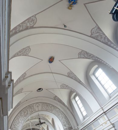 Zdjęcie nr 2: Kościół jest położony w centrum wsi, na wschód od głównej drogi, na placu otoczonym kamiennym murem przykrytym dachówką, z kilkoma drzewami. Wejście na plac przykościelny prowadzi przez szerokie schody i bramę od zachodu i bramkę od północy. Kościół jest budowlą założoną na planie prostokąta, jednonawowy, trójprzęsłowy z węższym, dwuprzęsłowym prezbiterium z apsydą. Do nawy przylegają od zachodu i północy dwie kruchty na planie kwadratu i wieża w narożu południowo-zachodnim fasady. Do prezbiterium od północy jest dostawiona kaplica na rzucie prostokąta otwierająca się półkolistymi arkadami, a od południa zakrystia. 
Artykulacja ścian jest przeprowadzona za pomocą zdwojonych pilastrów toskańskich stojących na wysokich postumentach i podtrzymujących wydatne, przełamujące się, pełne belkowanie z fryzem tryglifowym oraz wysuniętym gzymsem, obiegającym całe wnętrze świątyni. Wnętrze nakrywa sklepienie kolebkowe na gurtach z lunetami; w kluczach sklepienia znajdują się tarcze herbowe, Złota Pilawa oraz Ostoja. W lunetach umieszczone są okna prostokątne zamknięte łukiem odcinkowym; takie same okna znajdują się w apsydzie prezbiterium, poniżej belkowania.  W kaplicy znajdują się dwa prostokątne okna zamknięte odcinkowo. Zakrystia jest jednoprzestrzenna, nakryta sklepieniem krzyżowym. Prowadzi do niej kamienny portal profilowany z uszakami, z podwieszonymi wolutami, zwieńczony wydatnym gzymsem. W partii fryzu umieszczono polichromowany kartusz z herbem Ostoja. W ścianach środkowego przęsła korpusu nawowego po obu stronach kościoła znajdują się głębokie, prostokątne nisze zamknięte łukami odcinkowymi. W niszy północnej umieszczono drzwi prowadzące do niewielkiej kruchty przykrytej stropem, z dwoma małymi, okrągłymi oknami po bokach. Również po zachodniej stronie korpusu znajduje się wejście do kruchty. Ponadto na ścianach nawy oraz prezbiterium widnieją płyciny ujęte ramą profilowaną w tynku. W pierwszym od strony fasady przęśle znajduje się murowany chór muzyczny, trójarkadowy, wsparty na dwóch filarach opiętych pilastrami oraz dwóch półfilarach przylegających do ścian, sklepiony krzyżowo. 
Fasada kościoła jest płaska, zakończona gzymsem, z czterokondygnacyjną wieżą, nakrytą cebulastym hełmem z krzyżem. Boczne elewacje ujęte uskokowymi przyporami, zakończone gzymsem. Dachy dwuspadowe nad nawą i kruchtami, trójspadowe nad prezbiterium, półsferyczne nad apsydą, pulpitowe nad kaplicą i zakrystią, kryte blachą. Nad granicy nawy i prezbiterium wieloboczna wieżyczka na sygnaturkę z prześwitami, zakończona kopułą, sterczyną i kulą z krzyżem. 
