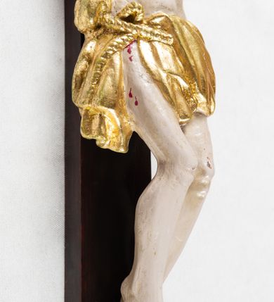 Zdjęcie nr 5: Krzyż o trójlistnym zakończeniu ramion. Rzeźba pełna; figura w typie Cristo morte, ciało w dużym zwisie, o układzie bliskim literze „Y”. Głowa przechylona na prawe ramię, nogi ugięte w kolanach, stopy przebite jednym gwoździem w układzie prawa na lewą. Twarz pociągła, o wyraźnych rysach, dużym nosie i pełnych ustach, okolona zarostem. Na głowie szeroka korona cierniowa. Sylwetka wychudzona, ciało z zaznaczonymi silnie mięśniami rąk i nóg oraz żebrami klatki piersiowej i mostkiem. Perizonium przewiązane sznurem, odsłaniające oba uda; tkanina drapowana, przerzucona przez sznur w partii podbrzusza. Polichromia naturalistyczna w odsłoniętych partiach ciała z zaznaczonymi śladami męki, perizonium złocone.
