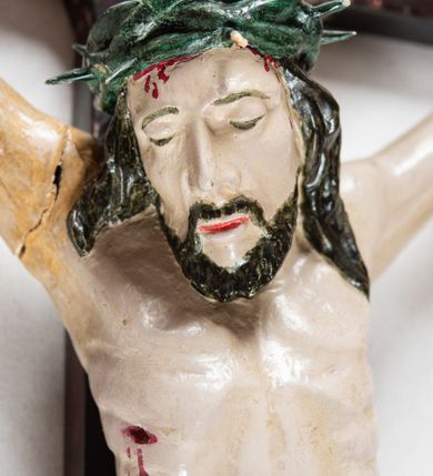 Zdjęcie nr 2: Krzyż o trójlistnym zakończeniu ramion. Rzeźba pełna; figura w typie Cristo morte, ciało w dużym zwisie, o układzie bliskim literze „Y”. Głowa przechylona na prawe ramię, nogi ugięte w kolanach, stopy przebite jednym gwoździem w układzie prawa na lewą. Twarz pociągła, o wyraźnych rysach, dużym nosie i pełnych ustach, okolona zarostem. Na głowie szeroka korona cierniowa. Sylwetka wychudzona, ciało z zaznaczonymi silnie mięśniami rąk i nóg oraz żebrami klatki piersiowej i mostkiem. Perizonium przewiązane sznurem, odsłaniające oba uda; tkanina drapowana, przerzucona przez sznur w partii podbrzusza. Polichromia naturalistyczna w odsłoniętych partiach ciała z zaznaczonymi śladami męki, perizonium złocone.