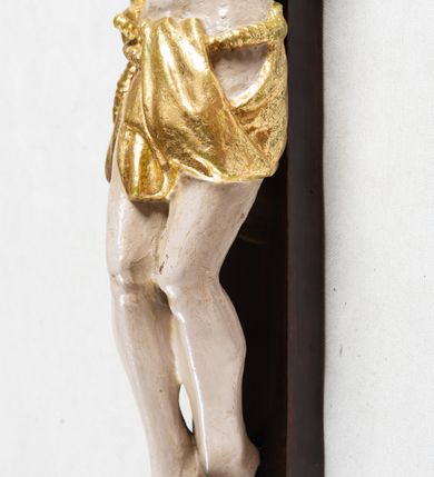 Zdjęcie nr 4: Krzyż o trójlistnym zakończeniu ramion. Rzeźba pełna; figura w typie Cristo morte, ciało w dużym zwisie, o układzie bliskim literze „Y”. Głowa przechylona na prawe ramię, nogi ugięte w kolanach, stopy przebite jednym gwoździem w układzie prawa na lewą. Twarz pociągła, o wyraźnych rysach, dużym nosie i pełnych ustach, okolona zarostem. Na głowie szeroka korona cierniowa. Sylwetka wychudzona, ciało z zaznaczonymi silnie mięśniami rąk i nóg oraz żebrami klatki piersiowej i mostkiem. Perizonium przewiązane sznurem, odsłaniające oba uda; tkanina drapowana, przerzucona przez sznur w partii podbrzusza. Polichromia naturalistyczna w odsłoniętych partiach ciała z zaznaczonymi śladami męki, perizonium złocone.