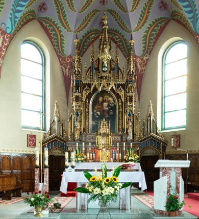 Zdjęcie nr 1: Ołtarz kamienny, prostopadłościenny, w drewnianej obudowie, ustawiony na trzystopniowej podstawie. Mensa i antependium drewniane, na przodzie flankowane dwiema parami blend, pole podzielone na trzy kwadratowe płyciny z maswerkami, w środkowej czwórliść z krzyżem.

Tabernakulum w formie prostopadłościennej skrzynki, na cokole, o ściętych przednich narożach. Drzwiczki metalowe, odlewane, w formie prostokąta stojącego, zamkniętego łukiem ostrym z przedstawieniem kielicha z hostią, otoczonego winną latoroślą i kłosami zboża na fakturowanym tle; w przyłuczach maswerki; naroża tabernakulum dekorowane blendami. Tron wystawienia w formie baldachimu, wspartego na parze kolumienek, o tylnej ściance wypełnionej maswerkami, po bokach flankowany wspornikami. Zwieńczenie  baldachimu w kształcie kopułki z latarnią, zdobionej naprzemiennie wimpergami i sterczynami.

Nastawa ołtarzowa architektoniczna, jednoosiowa z bramkami, jednokondygnacyjna ze zwieńczeniem, z predellą. Kondygnacja ujęta parą wysokich wieżyczek, podzielonych na dwie strefy: w dolnej nisze na figury św. Piotra i św. Pawła nakryte ostrołukowymi baldachimami ze sterczynami, w górnej nisze na niewielkich rozmiarów figurki św. Antoniego Padewskiego i św. Józefa, zakończone sterczynami z fialami. Pole środkowe na cokole, ujęte wysokimi, wąskimi kolumienkami dźwigającymi przyłucza wypełnione ornamentem roślinnym, które wspierają koronę utworzoną z trzech wimperg, wydzielonych sterczynami. W polu obraz „Śmierć św. Mikołaja z Tolentino” w formie prostokąta stojącego, zamkniętego łukiem ostrym, umieszczonego w profilowanej ramie. Obraz flankują dwie, pionowe wici roślinne. Na zasuwie obraz „Matki Boskiej Pocieszenia”, pędzla o. Grzegorza Parszywki z 1846 roku.

Zwieńczenie w formie kapliczki z figurą św. Jana Nepomucena, ujętej parą kolumienek podtrzymujących baldachim, którego krawędź dekorują naprzemiennie trzy wimpergi i sterczyny; całość zakończona fialą wypełnioną maswerkami. Zwieńczenie flankowane dwiema parami łuków nośnych ze wspornikami, których ażurowe przestrzenie wypełniają maswerki i blendy.  Bramki w formie arkad zamkniętych dwuspadowymi daszkami, podtrzymywanymi przez lizeny z blendami. Przejścia w kształcie prostokąta stojącego, zamkniętego łukiem półkolistym dekorowanym przy brzegu neogotyckim fartuchem, pole powyżej wypełniają blendy. Bramki zwieńczone ażurową konstrukcją utworzoną z wieżyczki, flankowanej przez łuki nośne ze sterczynami i ornamentem roślinnym.

Całość nastawy bogato zdobiona żabkami, motywem zwiniętego liścia i kwiatonami.

Struktura w kolorze naturalnego drewna, płyciny polichromowane na czerwono i niebiesko; kolumienki, ornamentyka, profile i detale architektoniczne złocone.
