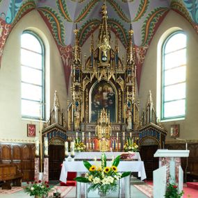 Zdjęcie nr 1: Ołtarz kamienny, prostopadłościenny, w drewnianej obudowie, ustawiony na trzystopniowej podstawie. Mensa i antependium drewniane, na przodzie flankowane dwiema parami blend, pole podzielone na trzy kwadratowe płyciny z maswerkami, w środkowej czwórliść z krzyżem.

Tabernakulum w formie prostopadłościennej skrzynki, na cokole, o ściętych przednich narożach. Drzwiczki metalowe, odlewane, w formie prostokąta stojącego, zamkniętego łukiem ostrym z przedstawieniem kielicha z hostią, otoczonego winną latoroślą i kłosami zboża na fakturowanym tle; w przyłuczach maswerki; naroża tabernakulum dekorowane blendami. Tron wystawienia w formie baldachimu, wspartego na parze kolumienek, o tylnej ściance wypełnionej maswerkami, po bokach flankowany wspornikami. Zwieńczenie  baldachimu w kształcie kopułki z latarnią, zdobionej naprzemiennie wimpergami i sterczynami.

Nastawa ołtarzowa architektoniczna, jednoosiowa z bramkami, jednokondygnacyjna ze zwieńczeniem, z predellą. Kondygnacja ujęta parą wysokich wieżyczek, podzielonych na dwie strefy: w dolnej nisze na figury św. Piotra i św. Pawła nakryte ostrołukowymi baldachimami ze sterczynami, w górnej nisze na niewielkich rozmiarów figurki św. Antoniego Padewskiego i św. Józefa, zakończone sterczynami z fialami. Pole środkowe na cokole, ujęte wysokimi, wąskimi kolumienkami dźwigającymi przyłucza wypełnione ornamentem roślinnym, które wspierają koronę utworzoną z trzech wimperg, wydzielonych sterczynami. W polu obraz „Śmierć św. Mikołaja z Tolentino” w formie prostokąta stojącego, zamkniętego łukiem ostrym, umieszczonego w profilowanej ramie. Obraz flankują dwie, pionowe wici roślinne. Na zasuwie obraz „Matki Boskiej Pocieszenia”, pędzla o. Grzegorza Parszywki z 1846 roku.

Zwieńczenie w formie kapliczki z figurą św. Jana Nepomucena, ujętej parą kolumienek podtrzymujących baldachim, którego krawędź dekorują naprzemiennie trzy wimpergi i sterczyny; całość zakończona fialą wypełnioną maswerkami. Zwieńczenie flankowane dwiema parami łuków nośnych ze wspornikami, których ażurowe przestrzenie wypełniają maswerki i blendy.  Bramki w formie arkad zamkniętych dwuspadowymi daszkami, podtrzymywanymi przez lizeny z blendami. Przejścia w kształcie prostokąta stojącego, zamkniętego łukiem półkolistym dekorowanym przy brzegu neogotyckim fartuchem, pole powyżej wypełniają blendy. Bramki zwieńczone ażurową konstrukcją utworzoną z wieżyczki, flankowanej przez łuki nośne ze sterczynami i ornamentem roślinnym.

Całość nastawy bogato zdobiona żabkami, motywem zwiniętego liścia i kwiatonami.

Struktura w kolorze naturalnego drewna, płyciny polichromowane na czerwono i niebiesko; kolumienki, ornamentyka, profile i detale architektoniczne złocone.
