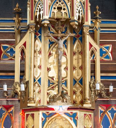 Zdjęcie nr 2: Ołtarz kamienny, prostopadłościenny, w drewnianej obudowie, ustawiony na trzystopniowej podstawie. Mensa i antependium drewniane, na przodzie flankowane dwiema parami blend, pole podzielone na trzy kwadratowe płyciny z maswerkami, w środkowej czwórliść z krzyżem.

Tabernakulum w formie prostopadłościennej skrzynki, na cokole, o ściętych przednich narożach. Drzwiczki metalowe, odlewane, w formie prostokąta stojącego, zamkniętego łukiem ostrym z przedstawieniem kielicha z hostią, otoczonego winną latoroślą i kłosami zboża na fakturowanym tle; w przyłuczach maswerki; naroża tabernakulum dekorowane blendami. Tron wystawienia w formie baldachimu, wspartego na parze kolumienek, o tylnej ściance wypełnionej maswerkami, po bokach flankowany wspornikami. Zwieńczenie  baldachimu w kształcie kopułki z latarnią, zdobionej naprzemiennie wimpergami i sterczynami.

Nastawa ołtarzowa architektoniczna, jednoosiowa z bramkami, jednokondygnacyjna ze zwieńczeniem, z predellą. Kondygnacja ujęta parą wysokich wieżyczek, podzielonych na dwie strefy: w dolnej nisze na figury św. Piotra i św. Pawła nakryte ostrołukowymi baldachimami ze sterczynami, w górnej nisze na niewielkich rozmiarów figurki św. Antoniego Padewskiego i św. Józefa, zakończone sterczynami z fialami. Pole środkowe na cokole, ujęte wysokimi, wąskimi kolumienkami dźwigającymi przyłucza wypełnione ornamentem roślinnym, które wspierają koronę utworzoną z trzech wimperg, wydzielonych sterczynami. W polu obraz „Śmierć św. Mikołaja z Tolentino” w formie prostokąta stojącego, zamkniętego łukiem ostrym, umieszczonego w profilowanej ramie. Obraz flankują dwie, pionowe wici roślinne. Na zasuwie obraz „Matki Boskiej Pocieszenia”, pędzla o. Grzegorza Parszywki z 1846 roku.

Zwieńczenie w formie kapliczki z figurą św. Jana Nepomucena, ujętej parą kolumienek podtrzymujących baldachim, którego krawędź dekorują naprzemiennie trzy wimpergi i sterczyny; całość zakończona fialą wypełnioną maswerkami. Zwieńczenie flankowane dwiema parami łuków nośnych ze wspornikami, których ażurowe przestrzenie wypełniają maswerki i blendy.  Bramki w formie arkad zamkniętych dwuspadowymi daszkami, podtrzymywanymi przez lizeny z blendami. Przejścia w kształcie prostokąta stojącego, zamkniętego łukiem półkolistym dekorowanym przy brzegu neogotyckim fartuchem, pole powyżej wypełniają blendy. Bramki zwieńczone ażurową konstrukcją utworzoną z wieżyczki, flankowanej przez łuki nośne ze sterczynami i ornamentem roślinnym.

Całość nastawy bogato zdobiona żabkami, motywem zwiniętego liścia i kwiatonami.

Struktura w kolorze naturalnego drewna, płyciny polichromowane na czerwono i niebiesko; kolumienki, ornamentyka, profile i detale architektoniczne złocone.
