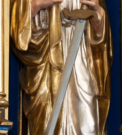 Zdjęcie nr 9: Ołtarz kamienny, prostopadłościenny, w drewnianej obudowie, ustawiony na trzystopniowej podstawie. Mensa i antependium drewniane, na przodzie flankowane dwiema parami blend, pole podzielone na trzy kwadratowe płyciny z maswerkami, w środkowej czwórliść z krzyżem.

Tabernakulum w formie prostopadłościennej skrzynki, na cokole, o ściętych przednich narożach. Drzwiczki metalowe, odlewane, w formie prostokąta stojącego, zamkniętego łukiem ostrym z przedstawieniem kielicha z hostią, otoczonego winną latoroślą i kłosami zboża na fakturowanym tle; w przyłuczach maswerki; naroża tabernakulum dekorowane blendami. Tron wystawienia w formie baldachimu, wspartego na parze kolumienek, o tylnej ściance wypełnionej maswerkami, po bokach flankowany wspornikami. Zwieńczenie  baldachimu w kształcie kopułki z latarnią, zdobionej naprzemiennie wimpergami i sterczynami.

Nastawa ołtarzowa architektoniczna, jednoosiowa z bramkami, jednokondygnacyjna ze zwieńczeniem, z predellą. Kondygnacja ujęta parą wysokich wieżyczek, podzielonych na dwie strefy: w dolnej nisze na figury św. Piotra i św. Pawła nakryte ostrołukowymi baldachimami ze sterczynami, w górnej nisze na niewielkich rozmiarów figurki św. Antoniego Padewskiego i św. Józefa, zakończone sterczynami z fialami. Pole środkowe na cokole, ujęte wysokimi, wąskimi kolumienkami dźwigającymi przyłucza wypełnione ornamentem roślinnym, które wspierają koronę utworzoną z trzech wimperg, wydzielonych sterczynami. W polu obraz „Śmierć św. Mikołaja z Tolentino” w formie prostokąta stojącego, zamkniętego łukiem ostrym, umieszczonego w profilowanej ramie. Obraz flankują dwie, pionowe wici roślinne. Na zasuwie obraz „Matki Boskiej Pocieszenia”, pędzla o. Grzegorza Parszywki z 1846 roku.

Zwieńczenie w formie kapliczki z figurą św. Jana Nepomucena, ujętej parą kolumienek podtrzymujących baldachim, którego krawędź dekorują naprzemiennie trzy wimpergi i sterczyny; całość zakończona fialą wypełnioną maswerkami. Zwieńczenie flankowane dwiema parami łuków nośnych ze wspornikami, których ażurowe przestrzenie wypełniają maswerki i blendy.  Bramki w formie arkad zamkniętych dwuspadowymi daszkami, podtrzymywanymi przez lizeny z blendami. Przejścia w kształcie prostokąta stojącego, zamkniętego łukiem półkolistym dekorowanym przy brzegu neogotyckim fartuchem, pole powyżej wypełniają blendy. Bramki zwieńczone ażurową konstrukcją utworzoną z wieżyczki, flankowanej przez łuki nośne ze sterczynami i ornamentem roślinnym.

Całość nastawy bogato zdobiona żabkami, motywem zwiniętego liścia i kwiatonami.

Struktura w kolorze naturalnego drewna, płyciny polichromowane na czerwono i niebiesko; kolumienki, ornamentyka, profile i detale architektoniczne złocone.
