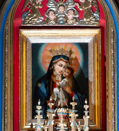 Zdjęcie nr 12: Ołtarz kamienny, prostopadłościenny, w drewnianej obudowie, ustawiony na trzystopniowej podstawie. Mensa i antependium drewniane, na przodzie flankowane dwiema parami blend, pole podzielone na trzy kwadratowe płyciny z maswerkami, w środkowej czwórliść z krzyżem.

Tabernakulum w formie prostopadłościennej skrzynki, na cokole, o ściętych przednich narożach. Drzwiczki metalowe, odlewane, w formie prostokąta stojącego, zamkniętego łukiem ostrym z przedstawieniem kielicha z hostią, otoczonego winną latoroślą i kłosami zboża na fakturowanym tle; w przyłuczach maswerki; naroża tabernakulum dekorowane blendami. Tron wystawienia w formie baldachimu, wspartego na parze kolumienek, o tylnej ściance wypełnionej maswerkami, po bokach flankowany wspornikami. Zwieńczenie  baldachimu w kształcie kopułki z latarnią, zdobionej naprzemiennie wimpergami i sterczynami.

Nastawa ołtarzowa architektoniczna, jednoosiowa z bramkami, jednokondygnacyjna ze zwieńczeniem, z predellą. Kondygnacja ujęta parą wysokich wieżyczek, podzielonych na dwie strefy: w dolnej nisze na figury św. Piotra i św. Pawła nakryte ostrołukowymi baldachimami ze sterczynami, w górnej nisze na niewielkich rozmiarów figurki św. Antoniego Padewskiego i św. Józefa, zakończone sterczynami z fialami. Pole środkowe na cokole, ujęte wysokimi, wąskimi kolumienkami dźwigającymi przyłucza wypełnione ornamentem roślinnym, które wspierają koronę utworzoną z trzech wimperg, wydzielonych sterczynami. W polu obraz „Śmierć św. Mikołaja z Tolentino” w formie prostokąta stojącego, zamkniętego łukiem ostrym, umieszczonego w profilowanej ramie. Obraz flankują dwie, pionowe wici roślinne. Na zasuwie obraz „Matki Boskiej Pocieszenia”, pędzla o. Grzegorza Parszywki z 1846 roku.

Zwieńczenie w formie kapliczki z figurą św. Jana Nepomucena, ujętej parą kolumienek podtrzymujących baldachim, którego krawędź dekorują naprzemiennie trzy wimpergi i sterczyny; całość zakończona fialą wypełnioną maswerkami. Zwieńczenie flankowane dwiema parami łuków nośnych ze wspornikami, których ażurowe przestrzenie wypełniają maswerki i blendy.  Bramki w formie arkad zamkniętych dwuspadowymi daszkami, podtrzymywanymi przez lizeny z blendami. Przejścia w kształcie prostokąta stojącego, zamkniętego łukiem półkolistym dekorowanym przy brzegu neogotyckim fartuchem, pole powyżej wypełniają blendy. Bramki zwieńczone ażurową konstrukcją utworzoną z wieżyczki, flankowanej przez łuki nośne ze sterczynami i ornamentem roślinnym.

Całość nastawy bogato zdobiona żabkami, motywem zwiniętego liścia i kwiatonami.

Struktura w kolorze naturalnego drewna, płyciny polichromowane na czerwono i niebiesko; kolumienki, ornamentyka, profile i detale architektoniczne złocone.
