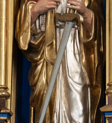 Zdjęcie nr 8: Ołtarz kamienny, prostopadłościenny, w drewnianej obudowie, ustawiony na trzystopniowej podstawie. Mensa i antependium drewniane, na przodzie flankowane dwiema parami blend, pole podzielone na trzy kwadratowe płyciny z maswerkami, w środkowej czwórliść z krzyżem.

Tabernakulum w formie prostopadłościennej skrzynki, na cokole, o ściętych przednich narożach. Drzwiczki metalowe, odlewane, w formie prostokąta stojącego, zamkniętego łukiem ostrym z przedstawieniem kielicha z hostią, otoczonego winną latoroślą i kłosami zboża na fakturowanym tle; w przyłuczach maswerki; naroża tabernakulum dekorowane blendami. Tron wystawienia w formie baldachimu, wspartego na parze kolumienek, o tylnej ściance wypełnionej maswerkami, po bokach flankowany wspornikami. Zwieńczenie  baldachimu w kształcie kopułki z latarnią, zdobionej naprzemiennie wimpergami i sterczynami.

Nastawa ołtarzowa architektoniczna, jednoosiowa z bramkami, jednokondygnacyjna ze zwieńczeniem, z predellą. Kondygnacja ujęta parą wysokich wieżyczek, podzielonych na dwie strefy: w dolnej nisze na figury św. Piotra i św. Pawła nakryte ostrołukowymi baldachimami ze sterczynami, w górnej nisze na niewielkich rozmiarów figurki św. Antoniego Padewskiego i św. Józefa, zakończone sterczynami z fialami. Pole środkowe na cokole, ujęte wysokimi, wąskimi kolumienkami dźwigającymi przyłucza wypełnione ornamentem roślinnym, które wspierają koronę utworzoną z trzech wimperg, wydzielonych sterczynami. W polu obraz „Śmierć św. Mikołaja z Tolentino” w formie prostokąta stojącego, zamkniętego łukiem ostrym, umieszczonego w profilowanej ramie. Obraz flankują dwie, pionowe wici roślinne. Na zasuwie obraz „Matki Boskiej Pocieszenia”, pędzla o. Grzegorza Parszywki z 1846 roku.

Zwieńczenie w formie kapliczki z figurą św. Jana Nepomucena, ujętej parą kolumienek podtrzymujących baldachim, którego krawędź dekorują naprzemiennie trzy wimpergi i sterczyny; całość zakończona fialą wypełnioną maswerkami. Zwieńczenie flankowane dwiema parami łuków nośnych ze wspornikami, których ażurowe przestrzenie wypełniają maswerki i blendy.  Bramki w formie arkad zamkniętych dwuspadowymi daszkami, podtrzymywanymi przez lizeny z blendami. Przejścia w kształcie prostokąta stojącego, zamkniętego łukiem półkolistym dekorowanym przy brzegu neogotyckim fartuchem, pole powyżej wypełniają blendy. Bramki zwieńczone ażurową konstrukcją utworzoną z wieżyczki, flankowanej przez łuki nośne ze sterczynami i ornamentem roślinnym.

Całość nastawy bogato zdobiona żabkami, motywem zwiniętego liścia i kwiatonami.

Struktura w kolorze naturalnego drewna, płyciny polichromowane na czerwono i niebiesko; kolumienki, ornamentyka, profile i detale architektoniczne złocone.
