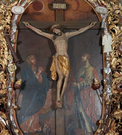 Zdjęcie nr 4: Nastawa ołtarzowa jednoosiowa, jednokondygnacyjna. Ołtarz prostopadłościenny, drewniany. Mensa z przodu dekorowana płyciną w kształcie prostokąta leżącego, malowaną na czerwono, w polu dwie gałązki palmowe i monogram IHS. Nastawa ustawiona jest na niskiej, trójosiowej predelli. Na osi głównej niewielkie tempietto, wsparte sześcioma kolumienkami z figurą Chrystusa Frasobliwego wewnątrz. Po bokach dwa obrazki z klęczącymi postaciami aniołów. Na osiach bocznych spływy wolutowe z półleżącymi postaciami aniołów oraz konsolki zdobione uskrzydlonymi główkami aniołków, skierowanymi na wprost. Predella podtrzymuje krucyfiks ustawiony na tle owalnego obrazu z Grupą Ukrzyżowania, obwiedzionego dokoła ramą z narzędziami Męki Pańskiej oraz bujną dekoracją ornamentu akantowego. Insygnia Arma Christii, kolejno od dołu, po lewej: obcęgi i młotek, pochodnia, włócznia z łańcuchem, kolumna, miecz z uchem Malchusa, rękawica, misa Piłata, Veraicon, misa z kośćmi do gry, suknia i drabina w jej tle, dzban Piłata, łańcuch i trzcina. U stóp krzyża napis: „Altare Confraternitatis Paupertatis Jesu Anno Dni 1703”. Po bokach dwie rzeźby aniołów. U dołu krzyża glob ziemski, opleciony przez węża; u góry na szczycie Veraikon i tarcza herbowa z herbem Szreniawa i literami „A. S. P. R.”. Dekoracja ornamentalna predelli okuciowa z kaboszonami, w kondygnacji akantowa. Polichromia struktury w kolorze bordowym, ornamentyka i profilowania złocone i srebrzone, detale czerwone.
