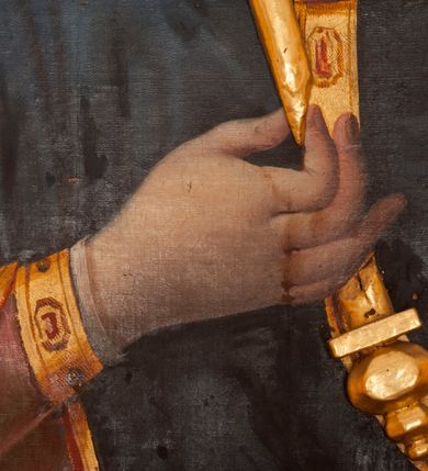 Zdjęcie nr 5: Obraz w formie stojącego prostokąta. Maria ukazana w półpostaci, zwrócona w trzech czwartych w lewo. W prawej, ugiętej ręce trzyma berło, lewą podtrzymuje Dzieciątko. Twarz ma owalną, o łagodnych rysach, migdałowatych oczach, długim nosie i pełnych ustach, okoloną jasnobrązowymi włosami. Ubrana jest w jasnoczerwoną suknię ze złoconymi lamówkami oraz granatowy maforion z czerwoną podszewką i złoconą lamówką zarzucony na głowę i ramiona, zapięty na piersi okrągłą klamrą. Dzieciątko ukazane w pozycji siedzącej, skierowane w trzech czwartych w prawo, z wysuniętą lewą nogą. Prawą rękę unosi w geście błogosławieństwa, lewą trzyma jabłko królewskie. Twarz ma kwadratową, o pełnych policzkach, dużych, migdałowatych oczach, małym nosie i pełnych ustach, okoloną krótkimi, brązowymi włosami. Ubrane jest w jasnoczerwoną tunikę ze złoconymi lamówkami, na stopach ma sandały. Maria i Dzieciątko mają na głowach zamknięte korony, a wokół nich nimby. Postacie ukazane są na srebrzonym tle wypełnionym wicią roślinną. Korony i berło rzeźbione są w drewnie, nałożone na płótno.