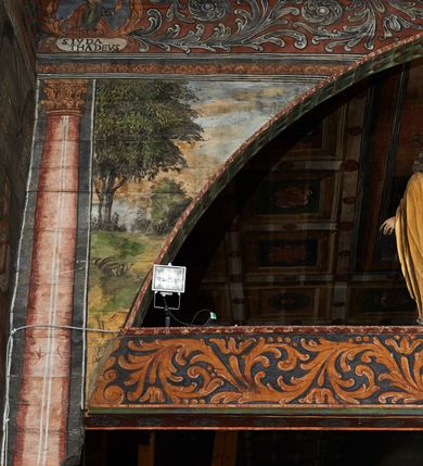 Zdjęcie nr 52: Polichromia ścienna prezbiterium pokrywa wszystkie ściany oraz strop tej części świątyni. 

Polichromia ścienna stropu
Strop zdobiony jest malowanymi kasetonami, w których umieszczone są rozety na różnokolorowych tłach. W centrum ukazane są dwie prostokątne kompozycje, ujęte w ornamentalne ramy. Od wschodu znajduje się Zwiastowanie Zachariaszowi, powyżej inskrypcja: „NE TIMEAS ZACHARIA VXOR TVA PARIET TIBI / FILIVM ET VOCABIS NOMEN EIVS IOANNEM LUCAE 1”. W drugiej kompozycji przedstawiono Nawiedzenie z Najświętszej Marii Panny ze św. Zachariaszem i św. Józefem, powyżej inskrypcja: „EXVLTAVIT IN GAVDIO INFANS IN VTERO MEO LUCAE 1”. 

Polichromia ścienna ścian prezbiterium
Dekoracje ścian o formie pasowej. W dolnej kondygnacji malowane iluzjonistycznie portrety świętych węgierskich w ornamentalnych ramach. Postacie ukazane do wysokości kolan, zwrócone trzy czwarte z odpowiednimi im atrybutami w dłoniach. Portrety opatrzone u góry łacińskimi opisami. Na ścianie północnej galerię otwiera wizerunek króla Stefana z napisem: „S(ANCTVS) STEPHANVS REX VNGARIAE, REGNVM SVVM DEIPARAE / DONAVIT OBIIT. 1038. 20 AVG(VSTVS) SEP. ALBERE 9.”. Następnie ukazani są kolejno: św. Emeryk „S(ANCTVS) EMERIGVS DVX VNGARIAE VT VIRGO MANERET, / A. CAELO PERSVASVS OBIIT. 1032. 5 nou. Sen. Albdvewas”, św. Władysław: „S(ANCTVS) LADISLAVS REX UNGARIAE ROSARIO ENSI OBVO/LUTO PVGNARE SOLITVS OBIIT 1097. 27.  iun. Sep. varad.”. Po drugiej stronie prezbiterium umieszczone są cztery obrazy świętych o tych samych wymiarach, również opatrzone napisami. Od lewej strony kolejno: św. Salomon „S(ANCTVS) SALOMON REX VNGARIAE DEIN EREMITA VITAE / AVSTERITATE FLORVIT OBIIT 1077. 28. Sept. Sep. Pold. in Idria”, św. Kazimierz: „S(ANCTVS) CASIMIRVS ELECTVS REX VNGARIAE AMORE / SARVANDAE VIRGINITATIS OBIIT 1484 4. MARTII.”, św. Dawid: „S(ANTCVS) DAVID REX SCOTIAE, FILIVS S(ANCTA) MARGA/RITAE VNGARA MATRE NATAE OBIIT 1153”, św. Ludwik: „S(SANCTVS) LVDOVICVS TOLOSANVS EP. E MARIA / REGIS VNG. FILIA NATVS OBIIT 1297 19 Aug(ustvs)”. Cykl ten kończy przy ścianie tęczowej przedstawienie św. Gintera „S(ANCVS) GVNTHERVS EREM. S(ANCTVS) STEPHANI REGIS / VNGARIAE COGNATVS OBIIT 1045 9. oct.”. Dodatkowo w obrazy wpisane są zacheuszki w formie równoramiennych krzyży ujętych w medaliony utworzone z wieńca. W zamknięciu prezbiterium przedstawienia diabłów, a od zachodu pod amboną czyściec.

Kondygnacja druga o podziałach architektonicznych u dołu wydzielona cokołem, dekorowanym złotymi girlandami na czarnym tle. Prostokątne pola wydzielone za pomocą malowanych iluzjonistycznie kolumn korynckich dźwigających architraw zdobiony stylizowanym kimationem jońskim. Powyżej fryz wypełniony wicią akantową, pomiędzy którą wplecione są kartusze z przedstawieniami świętych. W polach, pomiędzy kolumnami wielofigurowe kompozycje ze scenami z życia św. Jana Chrzciciela: Głos wołającego na pustyni „TV QVIS ES VOX CLAMANTIS IN DESERTO IOANN(IS) 1.”, Oto Baranek Boży „ECCE AGNVS DEI ECCE QVI TOLLIT PECCATVM MVNDI IOANN. IMÕ.”, Chrzest Jezusa w Jordanie „IESVS BAPTISTAVS EST A IONNE IN IORDANE MARCI. 1.”, Św. Jan Chrzciciel napomina Heroda „DICEBAT IOANNES HERODI NON LICET TIBI HABERE VXOREM FRATRIS TVI. MARCI 6,19.”, Św. Maria Magdalena pokutująca na pustyni, Św. Jan Chrzciciel na pustyni, Św. Jan Chrzciciel wtrącony do więzienia „HERODES TENVIT IONNEM ET VINXIT EVM IN CARCERE MAR 67o”, Kat podaje głowę św. Jana Chrzciciela Salome „DECOLLAVIT EVM IN CARCERE ET DEDIT CAPVT PVELLAE MAR.6.(?)”, Uczta Heroda „HERODES NATALIS SVI COENAM FECIT PRINCIPIBVS MAR. 6 10.”, Salome podaje głowę św. Jana Chrzciciela matce „CAPVT EIVS PVELLA DEDIT MATRI SVE M. 61”. 

W ostatniej, trzeciej strefie, umieszczonej w partii fryzu znajdują się medaliony. Na ścianie tęczowej, następnie na ścianie północnej i południowej ukazani są kolejno: św. Maciej „SA[N]CTVS / MATTHIAS”, Chrystus „IESVS / CHRISTVS”, św. Piotr „SANCTVS / PETRVS”, św. Szymon „SANCTVS / SIMON”, św. Andrzej „SANCTVS / ANDREAS”, św. Jakub Większy „S(ANCTVS) IACOBI / MAIORI”, św. Jan „(?)”, św. Filip „(?)”, św. Bartłomiej „SANCTVS / BARTHOLO/MAVS”, św. Tomasz „SANCTVS / THOMAS”, św. Mateusz „SANCTVS / MATTHAEVS”, św. Jakub Mniejszy „S(ANCTVS) IACOBVS / MINOR” i św. Juda Tadeusz „S(ANCVS) IVDA / THADEVS” na ścianie tęczowej od południa. Na belce tęczowej, od strony prezbiterium w wieńcu laurowym napis: „PICTVM / A[NNO] D[OMINI] 1711”.