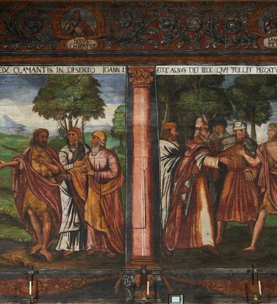 Zdjęcie nr 56: Polichromia ścienna prezbiterium pokrywa wszystkie ściany oraz strop tej części świątyni. 

Polichromia ścienna stropu
Strop zdobiony jest malowanymi kasetonami, w których umieszczone są rozety na różnokolorowych tłach. W centrum ukazane są dwie prostokątne kompozycje, ujęte w ornamentalne ramy. Od wschodu znajduje się Zwiastowanie Zachariaszowi, powyżej inskrypcja: „NE TIMEAS ZACHARIA VXOR TVA PARIET TIBI / FILIVM ET VOCABIS NOMEN EIVS IOANNEM LUCAE 1”. W drugiej kompozycji przedstawiono Nawiedzenie z Najświętszej Marii Panny ze św. Zachariaszem i św. Józefem, powyżej inskrypcja: „EXVLTAVIT IN GAVDIO INFANS IN VTERO MEO LUCAE 1”. 

Polichromia ścienna ścian prezbiterium
Dekoracje ścian o formie pasowej. W dolnej kondygnacji malowane iluzjonistycznie portrety świętych węgierskich w ornamentalnych ramach. Postacie ukazane do wysokości kolan, zwrócone trzy czwarte z odpowiednimi im atrybutami w dłoniach. Portrety opatrzone u góry łacińskimi opisami. Na ścianie północnej galerię otwiera wizerunek króla Stefana z napisem: „S(ANCTVS) STEPHANVS REX VNGARIAE, REGNVM SVVM DEIPARAE / DONAVIT OBIIT. 1038. 20 AVG(VSTVS) SEP. ALBERE 9.”. Następnie ukazani są kolejno: św. Emeryk „S(ANCTVS) EMERIGVS DVX VNGARIAE VT VIRGO MANERET, / A. CAELO PERSVASVS OBIIT. 1032. 5 nou. Sen. Albdvewas”, św. Władysław: „S(ANCTVS) LADISLAVS REX UNGARIAE ROSARIO ENSI OBVO/LUTO PVGNARE SOLITVS OBIIT 1097. 27.  iun. Sep. varad.”. Po drugiej stronie prezbiterium umieszczone są cztery obrazy świętych o tych samych wymiarach, również opatrzone napisami. Od lewej strony kolejno: św. Salomon „S(ANCTVS) SALOMON REX VNGARIAE DEIN EREMITA VITAE / AVSTERITATE FLORVIT OBIIT 1077. 28. Sept. Sep. Pold. in Idria”, św. Kazimierz: „S(ANCTVS) CASIMIRVS ELECTVS REX VNGARIAE AMORE / SARVANDAE VIRGINITATIS OBIIT 1484 4. MARTII.”, św. Dawid: „S(ANTCVS) DAVID REX SCOTIAE, FILIVS S(ANCTA) MARGA/RITAE VNGARA MATRE NATAE OBIIT 1153”, św. Ludwik: „S(SANCTVS) LVDOVICVS TOLOSANVS EP. E MARIA / REGIS VNG. FILIA NATVS OBIIT 1297 19 Aug(ustvs)”. Cykl ten kończy przy ścianie tęczowej przedstawienie św. Gintera „S(ANCVS) GVNTHERVS EREM. S(ANCTVS) STEPHANI REGIS / VNGARIAE COGNATVS OBIIT 1045 9. oct.”. Dodatkowo w obrazy wpisane są zacheuszki w formie równoramiennych krzyży ujętych w medaliony utworzone z wieńca. W zamknięciu prezbiterium przedstawienia diabłów, a od zachodu pod amboną czyściec.

Kondygnacja druga o podziałach architektonicznych u dołu wydzielona cokołem, dekorowanym złotymi girlandami na czarnym tle. Prostokątne pola wydzielone za pomocą malowanych iluzjonistycznie kolumn korynckich dźwigających architraw zdobiony stylizowanym kimationem jońskim. Powyżej fryz wypełniony wicią akantową, pomiędzy którą wplecione są kartusze z przedstawieniami świętych. W polach, pomiędzy kolumnami wielofigurowe kompozycje ze scenami z życia św. Jana Chrzciciela: Głos wołającego na pustyni „TV QVIS ES VOX CLAMANTIS IN DESERTO IOANN(IS) 1.”, Oto Baranek Boży „ECCE AGNVS DEI ECCE QVI TOLLIT PECCATVM MVNDI IOANN. IMÕ.”, Chrzest Jezusa w Jordanie „IESVS BAPTISTAVS EST A IONNE IN IORDANE MARCI. 1.”, Św. Jan Chrzciciel napomina Heroda „DICEBAT IOANNES HERODI NON LICET TIBI HABERE VXOREM FRATRIS TVI. MARCI 6,19.”, Św. Maria Magdalena pokutująca na pustyni, Św. Jan Chrzciciel na pustyni, Św. Jan Chrzciciel wtrącony do więzienia „HERODES TENVIT IONNEM ET VINXIT EVM IN CARCERE MAR 67o”, Kat podaje głowę św. Jana Chrzciciela Salome „DECOLLAVIT EVM IN CARCERE ET DEDIT CAPVT PVELLAE MAR.6.(?)”, Uczta Heroda „HERODES NATALIS SVI COENAM FECIT PRINCIPIBVS MAR. 6 10.”, Salome podaje głowę św. Jana Chrzciciela matce „CAPVT EIVS PVELLA DEDIT MATRI SVE M. 61”. 

W ostatniej, trzeciej strefie, umieszczonej w partii fryzu znajdują się medaliony. Na ścianie tęczowej, następnie na ścianie północnej i południowej ukazani są kolejno: św. Maciej „SA[N]CTVS / MATTHIAS”, Chrystus „IESVS / CHRISTVS”, św. Piotr „SANCTVS / PETRVS”, św. Szymon „SANCTVS / SIMON”, św. Andrzej „SANCTVS / ANDREAS”, św. Jakub Większy „S(ANCTVS) IACOBI / MAIORI”, św. Jan „(?)”, św. Filip „(?)”, św. Bartłomiej „SANCTVS / BARTHOLO/MAVS”, św. Tomasz „SANCTVS / THOMAS”, św. Mateusz „SANCTVS / MATTHAEVS”, św. Jakub Mniejszy „S(ANCTVS) IACOBVS / MINOR” i św. Juda Tadeusz „S(ANCVS) IVDA / THADEVS” na ścianie tęczowej od południa. Na belce tęczowej, od strony prezbiterium w wieńcu laurowym napis: „PICTVM / A[NNO] D[OMINI] 1711”.