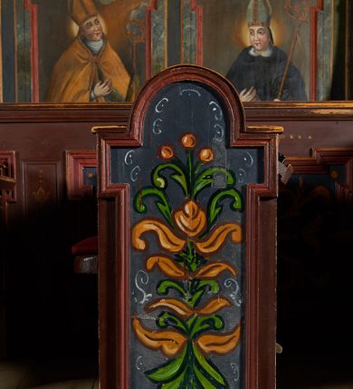 Zdjęcie nr 3: Polichromia ścienna prezbiterium pokrywa wszystkie ściany oraz strop tej części świątyni. 

Polichromia ścienna stropu
Strop zdobiony jest malowanymi kasetonami, w których umieszczone są rozety na różnokolorowych tłach. W centrum ukazane są dwie prostokątne kompozycje, ujęte w ornamentalne ramy. Od wschodu znajduje się Zwiastowanie Zachariaszowi, powyżej inskrypcja: „NE TIMEAS ZACHARIA VXOR TVA PARIET TIBI / FILIVM ET VOCABIS NOMEN EIVS IOANNEM LUCAE 1”. W drugiej kompozycji przedstawiono Nawiedzenie z Najświętszej Marii Panny ze św. Zachariaszem i św. Józefem, powyżej inskrypcja: „EXVLTAVIT IN GAVDIO INFANS IN VTERO MEO LUCAE 1”. 

Polichromia ścienna ścian prezbiterium
Dekoracje ścian o formie pasowej. W dolnej kondygnacji malowane iluzjonistycznie portrety świętych węgierskich w ornamentalnych ramach. Postacie ukazane do wysokości kolan, zwrócone trzy czwarte z odpowiednimi im atrybutami w dłoniach. Portrety opatrzone u góry łacińskimi opisami. Na ścianie północnej galerię otwiera wizerunek króla Stefana z napisem: „S(ANCTVS) STEPHANVS REX VNGARIAE, REGNVM SVVM DEIPARAE / DONAVIT OBIIT. 1038. 20 AVG(VSTVS) SEP. ALBERE 9.”. Następnie ukazani są kolejno: św. Emeryk „S(ANCTVS) EMERIGVS DVX VNGARIAE VT VIRGO MANERET, / A. CAELO PERSVASVS OBIIT. 1032. 5 nou. Sen. Albdvewas”, św. Władysław: „S(ANCTVS) LADISLAVS REX UNGARIAE ROSARIO ENSI OBVO/LUTO PVGNARE SOLITVS OBIIT 1097. 27.  iun. Sep. varad.”. Po drugiej stronie prezbiterium umieszczone są cztery obrazy świętych o tych samych wymiarach, również opatrzone napisami. Od lewej strony kolejno: św. Salomon „S(ANCTVS) SALOMON REX VNGARIAE DEIN EREMITA VITAE / AVSTERITATE FLORVIT OBIIT 1077. 28. Sept. Sep. Pold. in Idria”, św. Kazimierz: „S(ANCTVS) CASIMIRVS ELECTVS REX VNGARIAE AMORE / SARVANDAE VIRGINITATIS OBIIT 1484 4. MARTII.”, św. Dawid: „S(ANTCVS) DAVID REX SCOTIAE, FILIVS S(ANCTA) MARGA/RITAE VNGARA MATRE NATAE OBIIT 1153”, św. Ludwik: „S(SANCTVS) LVDOVICVS TOLOSANVS EP. E MARIA / REGIS VNG. FILIA NATVS OBIIT 1297 19 Aug(ustvs)”. Cykl ten kończy przy ścianie tęczowej przedstawienie św. Gintera „S(ANCVS) GVNTHERVS EREM. S(ANCTVS) STEPHANI REGIS / VNGARIAE COGNATVS OBIIT 1045 9. oct.”. Dodatkowo w obrazy wpisane są zacheuszki w formie równoramiennych krzyży ujętych w medaliony utworzone z wieńca. W zamknięciu prezbiterium przedstawienia diabłów, a od zachodu pod amboną czyściec.

Kondygnacja druga o podziałach architektonicznych u dołu wydzielona cokołem, dekorowanym złotymi girlandami na czarnym tle. Prostokątne pola wydzielone za pomocą malowanych iluzjonistycznie kolumn korynckich dźwigających architraw zdobiony stylizowanym kimationem jońskim. Powyżej fryz wypełniony wicią akantową, pomiędzy którą wplecione są kartusze z przedstawieniami świętych. W polach, pomiędzy kolumnami wielofigurowe kompozycje ze scenami z życia św. Jana Chrzciciela: Głos wołającego na pustyni „TV QVIS ES VOX CLAMANTIS IN DESERTO IOANN(IS) 1.”, Oto Baranek Boży „ECCE AGNVS DEI ECCE QVI TOLLIT PECCATVM MVNDI IOANN. IMÕ.”, Chrzest Jezusa w Jordanie „IESVS BAPTISTAVS EST A IONNE IN IORDANE MARCI. 1.”, Św. Jan Chrzciciel napomina Heroda „DICEBAT IOANNES HERODI NON LICET TIBI HABERE VXOREM FRATRIS TVI. MARCI 6,19.”, Św. Maria Magdalena pokutująca na pustyni, Św. Jan Chrzciciel na pustyni, Św. Jan Chrzciciel wtrącony do więzienia „HERODES TENVIT IONNEM ET VINXIT EVM IN CARCERE MAR 67o”, Kat podaje głowę św. Jana Chrzciciela Salome „DECOLLAVIT EVM IN CARCERE ET DEDIT CAPVT PVELLAE MAR.6.(?)”, Uczta Heroda „HERODES NATALIS SVI COENAM FECIT PRINCIPIBVS MAR. 6 10.”, Salome podaje głowę św. Jana Chrzciciela matce „CAPVT EIVS PVELLA DEDIT MATRI SVE M. 61”. 

W ostatniej, trzeciej strefie, umieszczonej w partii fryzu znajdują się medaliony. Na ścianie tęczowej, następnie na ścianie północnej i południowej ukazani są kolejno: św. Maciej „SA[N]CTVS / MATTHIAS”, Chrystus „IESVS / CHRISTVS”, św. Piotr „SANCTVS / PETRVS”, św. Szymon „SANCTVS / SIMON”, św. Andrzej „SANCTVS / ANDREAS”, św. Jakub Większy „S(ANCTVS) IACOBI / MAIORI”, św. Jan „(?)”, św. Filip „(?)”, św. Bartłomiej „SANCTVS / BARTHOLO/MAVS”, św. Tomasz „SANCTVS / THOMAS”, św. Mateusz „SANCTVS / MATTHAEVS”, św. Jakub Mniejszy „S(ANCTVS) IACOBVS / MINOR” i św. Juda Tadeusz „S(ANCVS) IVDA / THADEVS” na ścianie tęczowej od południa. Na belce tęczowej, od strony prezbiterium w wieńcu laurowym napis: „PICTVM / A[NNO] D[OMINI] 1711”.