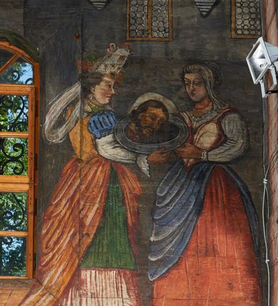 Zdjęcie nr 59: Polichromia ścienna prezbiterium pokrywa wszystkie ściany oraz strop tej części świątyni. 

Polichromia ścienna stropu
Strop zdobiony jest malowanymi kasetonami, w których umieszczone są rozety na różnokolorowych tłach. W centrum ukazane są dwie prostokątne kompozycje, ujęte w ornamentalne ramy. Od wschodu znajduje się Zwiastowanie Zachariaszowi, powyżej inskrypcja: „NE TIMEAS ZACHARIA VXOR TVA PARIET TIBI / FILIVM ET VOCABIS NOMEN EIVS IOANNEM LUCAE 1”. W drugiej kompozycji przedstawiono Nawiedzenie z Najświętszej Marii Panny ze św. Zachariaszem i św. Józefem, powyżej inskrypcja: „EXVLTAVIT IN GAVDIO INFANS IN VTERO MEO LUCAE 1”. 

Polichromia ścienna ścian prezbiterium
Dekoracje ścian o formie pasowej. W dolnej kondygnacji malowane iluzjonistycznie portrety świętych węgierskich w ornamentalnych ramach. Postacie ukazane do wysokości kolan, zwrócone trzy czwarte z odpowiednimi im atrybutami w dłoniach. Portrety opatrzone u góry łacińskimi opisami. Na ścianie północnej galerię otwiera wizerunek króla Stefana z napisem: „S(ANCTVS) STEPHANVS REX VNGARIAE, REGNVM SVVM DEIPARAE / DONAVIT OBIIT. 1038. 20 AVG(VSTVS) SEP. ALBERE 9.”. Następnie ukazani są kolejno: św. Emeryk „S(ANCTVS) EMERIGVS DVX VNGARIAE VT VIRGO MANERET, / A. CAELO PERSVASVS OBIIT. 1032. 5 nou. Sen. Albdvewas”, św. Władysław: „S(ANCTVS) LADISLAVS REX UNGARIAE ROSARIO ENSI OBVO/LUTO PVGNARE SOLITVS OBIIT 1097. 27.  iun. Sep. varad.”. Po drugiej stronie prezbiterium umieszczone są cztery obrazy świętych o tych samych wymiarach, również opatrzone napisami. Od lewej strony kolejno: św. Salomon „S(ANCTVS) SALOMON REX VNGARIAE DEIN EREMITA VITAE / AVSTERITATE FLORVIT OBIIT 1077. 28. Sept. Sep. Pold. in Idria”, św. Kazimierz: „S(ANCTVS) CASIMIRVS ELECTVS REX VNGARIAE AMORE / SARVANDAE VIRGINITATIS OBIIT 1484 4. MARTII.”, św. Dawid: „S(ANTCVS) DAVID REX SCOTIAE, FILIVS S(ANCTA) MARGA/RITAE VNGARA MATRE NATAE OBIIT 1153”, św. Ludwik: „S(SANCTVS) LVDOVICVS TOLOSANVS EP. E MARIA / REGIS VNG. FILIA NATVS OBIIT 1297 19 Aug(ustvs)”. Cykl ten kończy przy ścianie tęczowej przedstawienie św. Gintera „S(ANCVS) GVNTHERVS EREM. S(ANCTVS) STEPHANI REGIS / VNGARIAE COGNATVS OBIIT 1045 9. oct.”. Dodatkowo w obrazy wpisane są zacheuszki w formie równoramiennych krzyży ujętych w medaliony utworzone z wieńca. W zamknięciu prezbiterium przedstawienia diabłów, a od zachodu pod amboną czyściec.

Kondygnacja druga o podziałach architektonicznych u dołu wydzielona cokołem, dekorowanym złotymi girlandami na czarnym tle. Prostokątne pola wydzielone za pomocą malowanych iluzjonistycznie kolumn korynckich dźwigających architraw zdobiony stylizowanym kimationem jońskim. Powyżej fryz wypełniony wicią akantową, pomiędzy którą wplecione są kartusze z przedstawieniami świętych. W polach, pomiędzy kolumnami wielofigurowe kompozycje ze scenami z życia św. Jana Chrzciciela: Głos wołającego na pustyni „TV QVIS ES VOX CLAMANTIS IN DESERTO IOANN(IS) 1.”, Oto Baranek Boży „ECCE AGNVS DEI ECCE QVI TOLLIT PECCATVM MVNDI IOANN. IMÕ.”, Chrzest Jezusa w Jordanie „IESVS BAPTISTAVS EST A IONNE IN IORDANE MARCI. 1.”, Św. Jan Chrzciciel napomina Heroda „DICEBAT IOANNES HERODI NON LICET TIBI HABERE VXOREM FRATRIS TVI. MARCI 6,19.”, Św. Maria Magdalena pokutująca na pustyni, Św. Jan Chrzciciel na pustyni, Św. Jan Chrzciciel wtrącony do więzienia „HERODES TENVIT IONNEM ET VINXIT EVM IN CARCERE MAR 67o”, Kat podaje głowę św. Jana Chrzciciela Salome „DECOLLAVIT EVM IN CARCERE ET DEDIT CAPVT PVELLAE MAR.6.(?)”, Uczta Heroda „HERODES NATALIS SVI COENAM FECIT PRINCIPIBVS MAR. 6 10.”, Salome podaje głowę św. Jana Chrzciciela matce „CAPVT EIVS PVELLA DEDIT MATRI SVE M. 61”. 

W ostatniej, trzeciej strefie, umieszczonej w partii fryzu znajdują się medaliony. Na ścianie tęczowej, następnie na ścianie północnej i południowej ukazani są kolejno: św. Maciej „SA[N]CTVS / MATTHIAS”, Chrystus „IESVS / CHRISTVS”, św. Piotr „SANCTVS / PETRVS”, św. Szymon „SANCTVS / SIMON”, św. Andrzej „SANCTVS / ANDREAS”, św. Jakub Większy „S(ANCTVS) IACOBI / MAIORI”, św. Jan „(?)”, św. Filip „(?)”, św. Bartłomiej „SANCTVS / BARTHOLO/MAVS”, św. Tomasz „SANCTVS / THOMAS”, św. Mateusz „SANCTVS / MATTHAEVS”, św. Jakub Mniejszy „S(ANCTVS) IACOBVS / MINOR” i św. Juda Tadeusz „S(ANCVS) IVDA / THADEVS” na ścianie tęczowej od południa. Na belce tęczowej, od strony prezbiterium w wieńcu laurowym napis: „PICTVM / A[NNO] D[OMINI] 1711”.