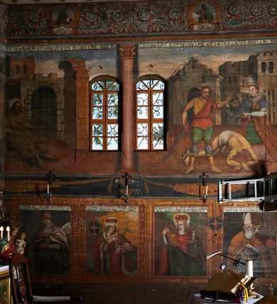 Zdjęcie nr 8: Polichromia ścienna prezbiterium pokrywa wszystkie ściany oraz strop tej części świątyni. 

Polichromia ścienna stropu
Strop zdobiony jest malowanymi kasetonami, w których umieszczone są rozety na różnokolorowych tłach. W centrum ukazane są dwie prostokątne kompozycje, ujęte w ornamentalne ramy. Od wschodu znajduje się Zwiastowanie Zachariaszowi, powyżej inskrypcja: „NE TIMEAS ZACHARIA VXOR TVA PARIET TIBI / FILIVM ET VOCABIS NOMEN EIVS IOANNEM LUCAE 1”. W drugiej kompozycji przedstawiono Nawiedzenie z Najświętszej Marii Panny ze św. Zachariaszem i św. Józefem, powyżej inskrypcja: „EXVLTAVIT IN GAVDIO INFANS IN VTERO MEO LUCAE 1”. 

Polichromia ścienna ścian prezbiterium
Dekoracje ścian o formie pasowej. W dolnej kondygnacji malowane iluzjonistycznie portrety świętych węgierskich w ornamentalnych ramach. Postacie ukazane do wysokości kolan, zwrócone trzy czwarte z odpowiednimi im atrybutami w dłoniach. Portrety opatrzone u góry łacińskimi opisami. Na ścianie północnej galerię otwiera wizerunek króla Stefana z napisem: „S(ANCTVS) STEPHANVS REX VNGARIAE, REGNVM SVVM DEIPARAE / DONAVIT OBIIT. 1038. 20 AVG(VSTVS) SEP. ALBERE 9.”. Następnie ukazani są kolejno: św. Emeryk „S(ANCTVS) EMERIGVS DVX VNGARIAE VT VIRGO MANERET, / A. CAELO PERSVASVS OBIIT. 1032. 5 nou. Sen. Albdvewas”, św. Władysław: „S(ANCTVS) LADISLAVS REX UNGARIAE ROSARIO ENSI OBVO/LUTO PVGNARE SOLITVS OBIIT 1097. 27.  iun. Sep. varad.”. Po drugiej stronie prezbiterium umieszczone są cztery obrazy świętych o tych samych wymiarach, również opatrzone napisami. Od lewej strony kolejno: św. Salomon „S(ANCTVS) SALOMON REX VNGARIAE DEIN EREMITA VITAE / AVSTERITATE FLORVIT OBIIT 1077. 28. Sept. Sep. Pold. in Idria”, św. Kazimierz: „S(ANCTVS) CASIMIRVS ELECTVS REX VNGARIAE AMORE / SARVANDAE VIRGINITATIS OBIIT 1484 4. MARTII.”, św. Dawid: „S(ANTCVS) DAVID REX SCOTIAE, FILIVS S(ANCTA) MARGA/RITAE VNGARA MATRE NATAE OBIIT 1153”, św. Ludwik: „S(SANCTVS) LVDOVICVS TOLOSANVS EP. E MARIA / REGIS VNG. FILIA NATVS OBIIT 1297 19 Aug(ustvs)”. Cykl ten kończy przy ścianie tęczowej przedstawienie św. Gintera „S(ANCVS) GVNTHERVS EREM. S(ANCTVS) STEPHANI REGIS / VNGARIAE COGNATVS OBIIT 1045 9. oct.”. Dodatkowo w obrazy wpisane są zacheuszki w formie równoramiennych krzyży ujętych w medaliony utworzone z wieńca. W zamknięciu prezbiterium przedstawienia diabłów, a od zachodu pod amboną czyściec.

Kondygnacja druga o podziałach architektonicznych u dołu wydzielona cokołem, dekorowanym złotymi girlandami na czarnym tle. Prostokątne pola wydzielone za pomocą malowanych iluzjonistycznie kolumn korynckich dźwigających architraw zdobiony stylizowanym kimationem jońskim. Powyżej fryz wypełniony wicią akantową, pomiędzy którą wplecione są kartusze z przedstawieniami świętych. W polach, pomiędzy kolumnami wielofigurowe kompozycje ze scenami z życia św. Jana Chrzciciela: Głos wołającego na pustyni „TV QVIS ES VOX CLAMANTIS IN DESERTO IOANN(IS) 1.”, Oto Baranek Boży „ECCE AGNVS DEI ECCE QVI TOLLIT PECCATVM MVNDI IOANN. IMÕ.”, Chrzest Jezusa w Jordanie „IESVS BAPTISTAVS EST A IONNE IN IORDANE MARCI. 1.”, Św. Jan Chrzciciel napomina Heroda „DICEBAT IOANNES HERODI NON LICET TIBI HABERE VXOREM FRATRIS TVI. MARCI 6,19.”, Św. Maria Magdalena pokutująca na pustyni, Św. Jan Chrzciciel na pustyni, Św. Jan Chrzciciel wtrącony do więzienia „HERODES TENVIT IONNEM ET VINXIT EVM IN CARCERE MAR 67o”, Kat podaje głowę św. Jana Chrzciciela Salome „DECOLLAVIT EVM IN CARCERE ET DEDIT CAPVT PVELLAE MAR.6.(?)”, Uczta Heroda „HERODES NATALIS SVI COENAM FECIT PRINCIPIBVS MAR. 6 10.”, Salome podaje głowę św. Jana Chrzciciela matce „CAPVT EIVS PVELLA DEDIT MATRI SVE M. 61”. 

W ostatniej, trzeciej strefie, umieszczonej w partii fryzu znajdują się medaliony. Na ścianie tęczowej, następnie na ścianie północnej i południowej ukazani są kolejno: św. Maciej „SA[N]CTVS / MATTHIAS”, Chrystus „IESVS / CHRISTVS”, św. Piotr „SANCTVS / PETRVS”, św. Szymon „SANCTVS / SIMON”, św. Andrzej „SANCTVS / ANDREAS”, św. Jakub Większy „S(ANCTVS) IACOBI / MAIORI”, św. Jan „(?)”, św. Filip „(?)”, św. Bartłomiej „SANCTVS / BARTHOLO/MAVS”, św. Tomasz „SANCTVS / THOMAS”, św. Mateusz „SANCTVS / MATTHAEVS”, św. Jakub Mniejszy „S(ANCTVS) IACOBVS / MINOR” i św. Juda Tadeusz „S(ANCVS) IVDA / THADEVS” na ścianie tęczowej od południa. Na belce tęczowej, od strony prezbiterium w wieńcu laurowym napis: „PICTVM / A[NNO] D[OMINI] 1711”.