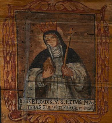 Zdjęcie nr 13: Polichromia ścienna nawy pokrywa wszystkie ściany oraz strop tej części świątyni. Polichromia figuralno-ornamentalna. W łuku tęczowym fryz podstropowy, wypełniony ornamentem w formie schematycznej, stylizowanej wici roślinnej, ujętej na krańcach uskrzydlonymi główkami anielskimi, umieszczonymi w medalionach. Poniżej fryzu, po lewej herb cesarski, ujęty w wieniec laurowy, w tle pejzaż; po przeciwnej stronie, zwieńczony insygniami biskupimi, herb biskupa Jerzego Lippay de Zongor – dwa lwy, ustawione antytetycznie przy ukoronowanej kolumnie.

Na północnej ścianie nawy do wysokości jednej trzeciej ściany pas kwater z wizerunkami świętych, ujętymi w obramienia, utworzone z ornamentu w formie silnie stylizowanej wici roślinnej. Pola pomiędzy kwaterami wypełnione schematycznym ornamentem geometryczno-figuralnym, złożonym ze skręconej wici roślinnej oraz główek anielskich. Od strony prezbiterium kolejno przedstawienia opatrzone następującymi podpisami:
„S(NCTVS) ADREAS ZOREARBUS EREMITA NITRAE / ET TRENCHINII  27 XIV LY ANNO 1609”;
„B. MATHEAI ESCANDELI NATUS BUDAE MARTIRIO AFFE/CTUS in Sinis quo infide infidelum convertendorum causa penefravit”;
„B. SADOCH ORD. PRAED. A. S. DOMINICO in UNGARIAM/ MISSUS EGREGIE LABORAVIT MARTYRIO  affectus 1260. 3. Iunii”;
„S(ANCTVS) COLOMANUS MS. MARGARITAE REGINAE SCOTIAE UNGARA/ MATRE NATAE FILIUS SUSPENSUS STOKARAVIAE COLIT 13 oct.”;
„S(ANCTVS) CAPISTRANI ORD. S. FRAC. TURCAS BELRADO FUGAVIT/ UNG. Ufilissim[us] obit 1455 23 Od. Viilaci in Ung. Sepult[us].”;
„S(ANCTVS) PETRUS THOMASIUS CARMELITA AT LUDOVICUM/ UNG. REGEM NUNTI[US] APOSTOL. De pace cum Venetis egit obit 29 9 1367”.

Kontynuacja przedstawień na ścianie zachodniej:
„B. IACOBUS PICENUS ORD. S. FRANC. S. CAPISTRANI IN UNG./ COAPOSTOL[US] MULTOS AD CHRISTI FIDEM CONVERTIT”;
„S(ANCTVS) IOANNES NEPOMUCN.”.

W górnej partii ściany północnej scena wielofiguralna: Św. Jan Chrzciciel nauczający w otoczeniu tłumu. W tle pejzaż z drzewami i  zarysowanym na najdalszym planie masywem górskim. Ponad przedstawieniem napis: „VENIT IN OMNEM REGIONEM PRAEDICANS BAPTISMUM POENITENITIAE LUCAE 3.”. Do sceny kazania św Jana Chrzciciela przylega środkowy rząd wizerunków świętych. Cztery pierwsze przedstawienia znajdują się na ścianie północnej i biegną w kierunku chóru muzycznego:
„B. BERTHODEUS (…) 17 DECE”;
„B. IOANNES DOMINICI ORD. PRAED. EP. Et. CARDIN ad. SIGISMUN. UN. BEC. NUNT. APOTOLIC. BUDAE obiit (…) 1418” [w lewym górnym rogu odnotowane białą farbą informacje o kolejnych konserwacjach polichromii];
„B. ANTONIUS UNGARUS ORD. FRANC. FULGINII/IN OBSEQUIO INFIRMORUM ob. 1398. 13 May.”;
„B. MATHAEUS ESCANDELI NATUS BUDA MARTIRIS AFFECTUS IN SINIS QUO INFIDELIUM…”.

Nad chórem muzycznym, na ścianie zachodniej znajdują się kolejne cztery wizerunki z tego cyklu:
„B. MURITIUS CSAKY ORD. PRAED AMORE IN DEIPURAM MIRACU/LIS CLARUS obiit laurmi 1336 20. Mar. [.]oii Ferr.”;
„B. MAURUS EX MANASTETRIO S. MARTINI /ORD. S. BENED. EPISC. QUINQUE ECCLESIENS in UNGARIA”;
„S(ANCTVS) BENEDICTUS MAR. EREMITA PROPE TRENCHINIUM/IN VASUM MERSUS COLITUR IM aii”;
„B. EUSEBIUS CANONICO STRIGOMI PRIMUS/PROVINCIALIS ORA: S. PAULI primi Erem: obit 1270. 20. Ian.”.

Ostatnie dwa wizerunki na ścianie południowej nad chórem muzycznym, kolejno od strony ściany tęczowej:
„S(ANCTVS) ASTRICQ ARCHIEN. COLOCENS. IN UNGARIA ORD./ s. BENEDICTI OBIIT. AN. 1034. 12 Novembris”;
„S(ANCTVS) PAULUS UNGARUS PRIMUS ORD. PRAED./ UNGARIA PROVINCIALIS MARTIRIO affectis”.

Na podniebiu zaskrzynienia kontynuacja cyklu hagiograficznego. Od łuku tęczowego, wizerunki umieszczone są między elementami ornamentacyjnym, opatrzone następującymi podpisami:
„B. GISELA S. STEPH. R. / U. CONIUX Ob. 1036”;
„S(ANCTVS) ESABETH ANDR. U. FI/LIA DUCISS THURINN ob. 1226”;
„B. GERTRUDIS V. FILIA/ S. ELISABETHAE THURING”;
„B. ELISABETH HELVETA AN/ DR III R.U. FILIA ob. 1338 6 mai”;
„B. HELENA V. ORD. PRAEDIC. OB. BUD. AN. 1720 9 nov.”;
„S(ANCTVS) MARGHARITA REGINA SCOTIAE NATA IN UNGARIA TEMORAE S. SALAMONIS”;
„B. ELISABETHU. Ord. Praed S. STEPHANI UNG. REGIS. FILIA OBIIT CIV. Anno 1285 6 martii”;
„S(ANCTA) URSULA CUM 11 000 VIRGINUM AB ATTILA INTERFECTA 1383 21 Oct.”.

Na podniebiu zaskrzynienia nad ścianą południową kontynuacja cyklu, od tęczy:
„B. MARGARITA FILIA BELAE 4 R. V. Ob. 1273. 28 Ian.”; 
„B. CUNEGUNDUDIS V. BELAE IV REG FILIA Ob. 1292. 24. 1.”.

Na ścianie południowej w dolnym pasie malowideł od strony tęczy scena figuralna z przedstawieniem św. Anny nauczającej Marię, a następnie scena piekła z przedstawieniem męki grzeszników w wypełnionej płomieniami paszczy Lewiatana. W górnej partii scena przedstawiająca pogrzeb Jana Chrzciciela. Przestrzenie wokół tego malowidła i okien szczelnie wypełnione ornamentem w formie schematycznej wici roślinnej. Drzwi pokryte dekoracją ornamentalną analogiczną do tej w przestrzeniach między obrazami w dolnym rzędzie cyklu świętych na ścianie północnej. Fryz przystropowy w całości dekorowany analogicznie jak w łuku tęczowym. 

Na stropie kontynuacja cyklu ze scenami z życia Jana Chrzciciela, rozpoczynającego się w prezbiterium. Dwa obrazy w formie prostokątów, ujęte w malowane ramy, utworzone z ornamentu złożonego z wici roślinnej i stylizowanych rozetek. Pierwsza od tęczy wielopostaciowa scena narodzin Jana Chrzciciela, w górnej partii opatrzona napisem: „QUIS PUTAS PUER ISTE ERITE IOANNES EST NOMEN EIUS LUCAE 1.”. Bliżej chóru przedstawienie Jana Chrzciciela, nauczającego na puszczy, opatrzona podpisem: „ERAT IN DESERTIS USQUE IN DIEM OSTENSIONIS SUAE LUCAE 1.”. Obrazy ujęte w iluzjonistycznie malowane kasetony z rozetami w środku. Podziały kasetonowe zaznaczone listewkami, dekorowanymi rozetkami. Pod amboną niewielkich rozmiarów malowidło, przedstawiające siedem postaci pokutujących w czyśćcu i anioła. Scena zwieńczona monogramem IHS.
