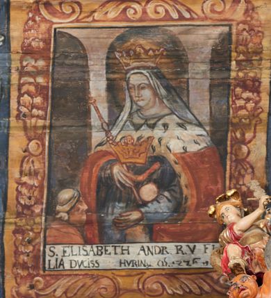 Zdjęcie nr 18: Polichromia ścienna nawy pokrywa wszystkie ściany oraz strop tej części świątyni. Polichromia figuralno-ornamentalna. W łuku tęczowym fryz podstropowy, wypełniony ornamentem w formie schematycznej, stylizowanej wici roślinnej, ujętej na krańcach uskrzydlonymi główkami anielskimi, umieszczonymi w medalionach. Poniżej fryzu, po lewej herb cesarski, ujęty w wieniec laurowy, w tle pejzaż; po przeciwnej stronie, zwieńczony insygniami biskupimi, herb biskupa Jerzego Lippay de Zongor – dwa lwy, ustawione antytetycznie przy ukoronowanej kolumnie.

Na północnej ścianie nawy do wysokości jednej trzeciej ściany pas kwater z wizerunkami świętych, ujętymi w obramienia, utworzone z ornamentu w formie silnie stylizowanej wici roślinnej. Pola pomiędzy kwaterami wypełnione schematycznym ornamentem geometryczno-figuralnym, złożonym ze skręconej wici roślinnej oraz główek anielskich. Od strony prezbiterium kolejno przedstawienia opatrzone następującymi podpisami:
„S(NCTVS) ADREAS ZOREARBUS EREMITA NITRAE / ET TRENCHINII  27 XIV LY ANNO 1609”;
„B. MATHEAI ESCANDELI NATUS BUDAE MARTIRIO AFFE/CTUS in Sinis quo infide infidelum convertendorum causa penefravit”;
„B. SADOCH ORD. PRAED. A. S. DOMINICO in UNGARIAM/ MISSUS EGREGIE LABORAVIT MARTYRIO  affectus 1260. 3. Iunii”;
„S(ANCTVS) COLOMANUS MS. MARGARITAE REGINAE SCOTIAE UNGARA/ MATRE NATAE FILIUS SUSPENSUS STOKARAVIAE COLIT 13 oct.”;
„S(ANCTVS) CAPISTRANI ORD. S. FRAC. TURCAS BELRADO FUGAVIT/ UNG. Ufilissim[us] obit 1455 23 Od. Viilaci in Ung. Sepult[us].”;
„S(ANCTVS) PETRUS THOMASIUS CARMELITA AT LUDOVICUM/ UNG. REGEM NUNTI[US] APOSTOL. De pace cum Venetis egit obit 29 9 1367”.

Kontynuacja przedstawień na ścianie zachodniej:
„B. IACOBUS PICENUS ORD. S. FRANC. S. CAPISTRANI IN UNG./ COAPOSTOL[US] MULTOS AD CHRISTI FIDEM CONVERTIT”;
„S(ANCTVS) IOANNES NEPOMUCN.”.

W górnej partii ściany północnej scena wielofiguralna: Św. Jan Chrzciciel nauczający w otoczeniu tłumu. W tle pejzaż z drzewami i  zarysowanym na najdalszym planie masywem górskim. Ponad przedstawieniem napis: „VENIT IN OMNEM REGIONEM PRAEDICANS BAPTISMUM POENITENITIAE LUCAE 3.”. Do sceny kazania św Jana Chrzciciela przylega środkowy rząd wizerunków świętych. Cztery pierwsze przedstawienia znajdują się na ścianie północnej i biegną w kierunku chóru muzycznego:
„B. BERTHODEUS (…) 17 DECE”;
„B. IOANNES DOMINICI ORD. PRAED. EP. Et. CARDIN ad. SIGISMUN. UN. BEC. NUNT. APOTOLIC. BUDAE obiit (…) 1418” [w lewym górnym rogu odnotowane białą farbą informacje o kolejnych konserwacjach polichromii];
„B. ANTONIUS UNGARUS ORD. FRANC. FULGINII/IN OBSEQUIO INFIRMORUM ob. 1398. 13 May.”;
„B. MATHAEUS ESCANDELI NATUS BUDA MARTIRIS AFFECTUS IN SINIS QUO INFIDELIUM…”.

Nad chórem muzycznym, na ścianie zachodniej znajdują się kolejne cztery wizerunki z tego cyklu:
„B. MURITIUS CSAKY ORD. PRAED AMORE IN DEIPURAM MIRACU/LIS CLARUS obiit laurmi 1336 20. Mar. [.]oii Ferr.”;
„B. MAURUS EX MANASTETRIO S. MARTINI /ORD. S. BENED. EPISC. QUINQUE ECCLESIENS in UNGARIA”;
„S(ANCTVS) BENEDICTUS MAR. EREMITA PROPE TRENCHINIUM/IN VASUM MERSUS COLITUR IM aii”;
„B. EUSEBIUS CANONICO STRIGOMI PRIMUS/PROVINCIALIS ORA: S. PAULI primi Erem: obit 1270. 20. Ian.”.

Ostatnie dwa wizerunki na ścianie południowej nad chórem muzycznym, kolejno od strony ściany tęczowej:
„S(ANCTVS) ASTRICQ ARCHIEN. COLOCENS. IN UNGARIA ORD./ s. BENEDICTI OBIIT. AN. 1034. 12 Novembris”;
„S(ANCTVS) PAULUS UNGARUS PRIMUS ORD. PRAED./ UNGARIA PROVINCIALIS MARTIRIO affectis”.

Na podniebiu zaskrzynienia kontynuacja cyklu hagiograficznego. Od łuku tęczowego, wizerunki umieszczone są między elementami ornamentacyjnym, opatrzone następującymi podpisami:
„B. GISELA S. STEPH. R. / U. CONIUX Ob. 1036”;
„S(ANCTVS) ESABETH ANDR. U. FI/LIA DUCISS THURINN ob. 1226”;
„B. GERTRUDIS V. FILIA/ S. ELISABETHAE THURING”;
„B. ELISABETH HELVETA AN/ DR III R.U. FILIA ob. 1338 6 mai”;
„B. HELENA V. ORD. PRAEDIC. OB. BUD. AN. 1720 9 nov.”;
„S(ANCTVS) MARGHARITA REGINA SCOTIAE NATA IN UNGARIA TEMORAE S. SALAMONIS”;
„B. ELISABETHU. Ord. Praed S. STEPHANI UNG. REGIS. FILIA OBIIT CIV. Anno 1285 6 martii”;
„S(ANCTA) URSULA CUM 11 000 VIRGINUM AB ATTILA INTERFECTA 1383 21 Oct.”.

Na podniebiu zaskrzynienia nad ścianą południową kontynuacja cyklu, od tęczy:
„B. MARGARITA FILIA BELAE 4 R. V. Ob. 1273. 28 Ian.”; 
„B. CUNEGUNDUDIS V. BELAE IV REG FILIA Ob. 1292. 24. 1.”.

Na ścianie południowej w dolnym pasie malowideł od strony tęczy scena figuralna z przedstawieniem św. Anny nauczającej Marię, a następnie scena piekła z przedstawieniem męki grzeszników w wypełnionej płomieniami paszczy Lewiatana. W górnej partii scena przedstawiająca pogrzeb Jana Chrzciciela. Przestrzenie wokół tego malowidła i okien szczelnie wypełnione ornamentem w formie schematycznej wici roślinnej. Drzwi pokryte dekoracją ornamentalną analogiczną do tej w przestrzeniach między obrazami w dolnym rzędzie cyklu świętych na ścianie północnej. Fryz przystropowy w całości dekorowany analogicznie jak w łuku tęczowym. 

Na stropie kontynuacja cyklu ze scenami z życia Jana Chrzciciela, rozpoczynającego się w prezbiterium. Dwa obrazy w formie prostokątów, ujęte w malowane ramy, utworzone z ornamentu złożonego z wici roślinnej i stylizowanych rozetek. Pierwsza od tęczy wielopostaciowa scena narodzin Jana Chrzciciela, w górnej partii opatrzona napisem: „QUIS PUTAS PUER ISTE ERITE IOANNES EST NOMEN EIUS LUCAE 1.”. Bliżej chóru przedstawienie Jana Chrzciciela, nauczającego na puszczy, opatrzona podpisem: „ERAT IN DESERTIS USQUE IN DIEM OSTENSIONIS SUAE LUCAE 1.”. Obrazy ujęte w iluzjonistycznie malowane kasetony z rozetami w środku. Podziały kasetonowe zaznaczone listewkami, dekorowanymi rozetkami. Pod amboną niewielkich rozmiarów malowidło, przedstawiające siedem postaci pokutujących w czyśćcu i anioła. Scena zwieńczona monogramem IHS.
