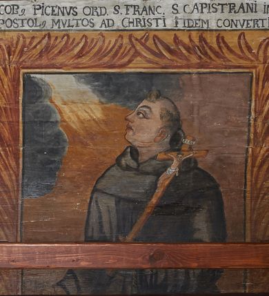 Zdjęcie nr 33: Polichromia ścienna nawy pokrywa wszystkie ściany oraz strop tej części świątyni. Polichromia figuralno-ornamentalna. W łuku tęczowym fryz podstropowy, wypełniony ornamentem w formie schematycznej, stylizowanej wici roślinnej, ujętej na krańcach uskrzydlonymi główkami anielskimi, umieszczonymi w medalionach. Poniżej fryzu, po lewej herb cesarski, ujęty w wieniec laurowy, w tle pejzaż; po przeciwnej stronie, zwieńczony insygniami biskupimi, herb biskupa Jerzego Lippay de Zongor – dwa lwy, ustawione antytetycznie przy ukoronowanej kolumnie.

Na północnej ścianie nawy do wysokości jednej trzeciej ściany pas kwater z wizerunkami świętych, ujętymi w obramienia, utworzone z ornamentu w formie silnie stylizowanej wici roślinnej. Pola pomiędzy kwaterami wypełnione schematycznym ornamentem geometryczno-figuralnym, złożonym ze skręconej wici roślinnej oraz główek anielskich. Od strony prezbiterium kolejno przedstawienia opatrzone następującymi podpisami:
„S(NCTVS) ADREAS ZOREARBUS EREMITA NITRAE / ET TRENCHINII  27 XIV LY ANNO 1609”;
„B. MATHEAI ESCANDELI NATUS BUDAE MARTIRIO AFFE/CTUS in Sinis quo infide infidelum convertendorum causa penefravit”;
„B. SADOCH ORD. PRAED. A. S. DOMINICO in UNGARIAM/ MISSUS EGREGIE LABORAVIT MARTYRIO  affectus 1260. 3. Iunii”;
„S(ANCTVS) COLOMANUS MS. MARGARITAE REGINAE SCOTIAE UNGARA/ MATRE NATAE FILIUS SUSPENSUS STOKARAVIAE COLIT 13 oct.”;
„S(ANCTVS) CAPISTRANI ORD. S. FRAC. TURCAS BELRADO FUGAVIT/ UNG. Ufilissim[us] obit 1455 23 Od. Viilaci in Ung. Sepult[us].”;
„S(ANCTVS) PETRUS THOMASIUS CARMELITA AT LUDOVICUM/ UNG. REGEM NUNTI[US] APOSTOL. De pace cum Venetis egit obit 29 9 1367”.

Kontynuacja przedstawień na ścianie zachodniej:
„B. IACOBUS PICENUS ORD. S. FRANC. S. CAPISTRANI IN UNG./ COAPOSTOL[US] MULTOS AD CHRISTI FIDEM CONVERTIT”;
„S(ANCTVS) IOANNES NEPOMUCN.”.

W górnej partii ściany północnej scena wielofiguralna: Św. Jan Chrzciciel nauczający w otoczeniu tłumu. W tle pejzaż z drzewami i  zarysowanym na najdalszym planie masywem górskim. Ponad przedstawieniem napis: „VENIT IN OMNEM REGIONEM PRAEDICANS BAPTISMUM POENITENITIAE LUCAE 3.”. Do sceny kazania św Jana Chrzciciela przylega środkowy rząd wizerunków świętych. Cztery pierwsze przedstawienia znajdują się na ścianie północnej i biegną w kierunku chóru muzycznego:
„B. BERTHODEUS (…) 17 DECE”;
„B. IOANNES DOMINICI ORD. PRAED. EP. Et. CARDIN ad. SIGISMUN. UN. BEC. NUNT. APOTOLIC. BUDAE obiit (…) 1418” [w lewym górnym rogu odnotowane białą farbą informacje o kolejnych konserwacjach polichromii];
„B. ANTONIUS UNGARUS ORD. FRANC. FULGINII/IN OBSEQUIO INFIRMORUM ob. 1398. 13 May.”;
„B. MATHAEUS ESCANDELI NATUS BUDA MARTIRIS AFFECTUS IN SINIS QUO INFIDELIUM…”.

Nad chórem muzycznym, na ścianie zachodniej znajdują się kolejne cztery wizerunki z tego cyklu:
„B. MURITIUS CSAKY ORD. PRAED AMORE IN DEIPURAM MIRACU/LIS CLARUS obiit laurmi 1336 20. Mar. [.]oii Ferr.”;
„B. MAURUS EX MANASTETRIO S. MARTINI /ORD. S. BENED. EPISC. QUINQUE ECCLESIENS in UNGARIA”;
„S(ANCTVS) BENEDICTUS MAR. EREMITA PROPE TRENCHINIUM/IN VASUM MERSUS COLITUR IM aii”;
„B. EUSEBIUS CANONICO STRIGOMI PRIMUS/PROVINCIALIS ORA: S. PAULI primi Erem: obit 1270. 20. Ian.”.

Ostatnie dwa wizerunki na ścianie południowej nad chórem muzycznym, kolejno od strony ściany tęczowej:
„S(ANCTVS) ASTRICQ ARCHIEN. COLOCENS. IN UNGARIA ORD./ s. BENEDICTI OBIIT. AN. 1034. 12 Novembris”;
„S(ANCTVS) PAULUS UNGARUS PRIMUS ORD. PRAED./ UNGARIA PROVINCIALIS MARTIRIO affectis”.

Na podniebiu zaskrzynienia kontynuacja cyklu hagiograficznego. Od łuku tęczowego, wizerunki umieszczone są między elementami ornamentacyjnym, opatrzone następującymi podpisami:
„B. GISELA S. STEPH. R. / U. CONIUX Ob. 1036”;
„S(ANCTVS) ESABETH ANDR. U. FI/LIA DUCISS THURINN ob. 1226”;
„B. GERTRUDIS V. FILIA/ S. ELISABETHAE THURING”;
„B. ELISABETH HELVETA AN/ DR III R.U. FILIA ob. 1338 6 mai”;
„B. HELENA V. ORD. PRAEDIC. OB. BUD. AN. 1720 9 nov.”;
„S(ANCTVS) MARGHARITA REGINA SCOTIAE NATA IN UNGARIA TEMORAE S. SALAMONIS”;
„B. ELISABETHU. Ord. Praed S. STEPHANI UNG. REGIS. FILIA OBIIT CIV. Anno 1285 6 martii”;
„S(ANCTA) URSULA CUM 11 000 VIRGINUM AB ATTILA INTERFECTA 1383 21 Oct.”.

Na podniebiu zaskrzynienia nad ścianą południową kontynuacja cyklu, od tęczy:
„B. MARGARITA FILIA BELAE 4 R. V. Ob. 1273. 28 Ian.”; 
„B. CUNEGUNDUDIS V. BELAE IV REG FILIA Ob. 1292. 24. 1.”.

Na ścianie południowej w dolnym pasie malowideł od strony tęczy scena figuralna z przedstawieniem św. Anny nauczającej Marię, a następnie scena piekła z przedstawieniem męki grzeszników w wypełnionej płomieniami paszczy Lewiatana. W górnej partii scena przedstawiająca pogrzeb Jana Chrzciciela. Przestrzenie wokół tego malowidła i okien szczelnie wypełnione ornamentem w formie schematycznej wici roślinnej. Drzwi pokryte dekoracją ornamentalną analogiczną do tej w przestrzeniach między obrazami w dolnym rzędzie cyklu świętych na ścianie północnej. Fryz przystropowy w całości dekorowany analogicznie jak w łuku tęczowym. 

Na stropie kontynuacja cyklu ze scenami z życia Jana Chrzciciela, rozpoczynającego się w prezbiterium. Dwa obrazy w formie prostokątów, ujęte w malowane ramy, utworzone z ornamentu złożonego z wici roślinnej i stylizowanych rozetek. Pierwsza od tęczy wielopostaciowa scena narodzin Jana Chrzciciela, w górnej partii opatrzona napisem: „QUIS PUTAS PUER ISTE ERITE IOANNES EST NOMEN EIUS LUCAE 1.”. Bliżej chóru przedstawienie Jana Chrzciciela, nauczającego na puszczy, opatrzona podpisem: „ERAT IN DESERTIS USQUE IN DIEM OSTENSIONIS SUAE LUCAE 1.”. Obrazy ujęte w iluzjonistycznie malowane kasetony z rozetami w środku. Podziały kasetonowe zaznaczone listewkami, dekorowanymi rozetkami. Pod amboną niewielkich rozmiarów malowidło, przedstawiające siedem postaci pokutujących w czyśćcu i anioła. Scena zwieńczona monogramem IHS.
