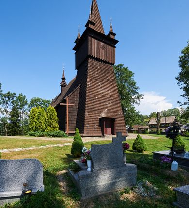 Zdjęcie nr 3: Kościół św. Jana Chrzciciela w Orawce usytuowany jest w centrum wsi na zachód od drogi prowadzącej z Jabłonki do Podwilka. Jest otoczony starodrzewiem, teren przykościelny opasany jest murem z łamanego kamienia. W granicach ogrodzenia znajduje się rozległy cmentarz przykościelny. 

Kościół orientowany, drewniany, konstrukcji zrębowej z wieżą na słup na kamiennej podmurówce. Prezbiterium wydłużone i zamknięte wielobocznie, nawa szersza i prostokątna. Przy prezbiterium od północy usytuowana jest zakrystia, a od wschodu murowana kaplica Matki Boskiej Bolesnej z 1728 roku o wielobocznym zakończeniu z przybudówką w rodzaju zakrystii od północy. Świątynia zbudowana jest z bierwion, łączonych na kwadratowy czop, bez ostatków. Poszczególne barwiona umocnione są pionowo tyblami. 

Wnętrze kościoła nakrywają stropy drewniane, płaskie, w nawie z zaskrzynieniami, podpartymi słupami. Zaskrzynienia w nawie obite są deskami dekorowanymi polichromią. W kaplicy Matki Boskiej Bolesnej sklepienie kolebkowe z lunetami. Ściana arkady tęczowej zamknięta jest łukiem półkolistym, na belce tęczowej umieszczona jest Grupa Ukrzyżowania. Przy nawie od południa dobudowana jest nowsza, drewniana kruchta. Chór muzyczny wsparty na dwóch profilowanych słupach z nim złączony chórek boczny przy północnej ścianie nawy. Otwory okienne usytuowane wyłącznie od strony południowej w kształcie stojących prostokątów, zamknięte półkoliście.

Na zewnątrz ściany świątyni obite gontem z wyjątkiem murowanej kaplicy Matki Boskiej Bolesnej, która została otynkowana. Wieża częściowo wtopiona w korpus, częściowo wysunięta ryzalitycznie; w przyziemiu babiniec. Wieża wzniesiona w konstrukcji słupowo-ramowej, główne narożne słupy nośne pochylone, wzmocnione tzw. krzyżami św. Andrzeja. Wieża zwieńczona jest nadwieszoną izbicą, szalowaną deskami w układzie pionowym z listwowaniem z czterolistnymi okienkami. Wyżej ostrosłupowy hełm z czterema narożnymi wieżyczkami. Kościół nakryty gontem w postaci długiego, kalenicowego dachu o rozległych połaciach, otulonym płaszczem gontowym z szerokim, załamanym okapem. Na wspólnym dachu kościoła i kaplicy nowa wieżyczka na sygnaturkę. 