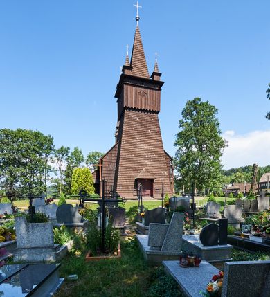 Zdjęcie nr 2: Kościół św. Jana Chrzciciela w Orawce usytuowany jest w centrum wsi na zachód od drogi prowadzącej z Jabłonki do Podwilka. Jest otoczony starodrzewiem, teren przykościelny opasany jest murem z łamanego kamienia. W granicach ogrodzenia znajduje się rozległy cmentarz przykościelny. 

Kościół orientowany, drewniany, konstrukcji zrębowej z wieżą na słup na kamiennej podmurówce. Prezbiterium wydłużone i zamknięte wielobocznie, nawa szersza i prostokątna. Przy prezbiterium od północy usytuowana jest zakrystia, a od wschodu murowana kaplica Matki Boskiej Bolesnej z 1728 roku o wielobocznym zakończeniu z przybudówką w rodzaju zakrystii od północy. Świątynia zbudowana jest z bierwion, łączonych na kwadratowy czop, bez ostatków. Poszczególne barwiona umocnione są pionowo tyblami. 

Wnętrze kościoła nakrywają stropy drewniane, płaskie, w nawie z zaskrzynieniami, podpartymi słupami. Zaskrzynienia w nawie obite są deskami dekorowanymi polichromią. W kaplicy Matki Boskiej Bolesnej sklepienie kolebkowe z lunetami. Ściana arkady tęczowej zamknięta jest łukiem półkolistym, na belce tęczowej umieszczona jest Grupa Ukrzyżowania. Przy nawie od południa dobudowana jest nowsza, drewniana kruchta. Chór muzyczny wsparty na dwóch profilowanych słupach z nim złączony chórek boczny przy północnej ścianie nawy. Otwory okienne usytuowane wyłącznie od strony południowej w kształcie stojących prostokątów, zamknięte półkoliście.

Na zewnątrz ściany świątyni obite gontem z wyjątkiem murowanej kaplicy Matki Boskiej Bolesnej, która została otynkowana. Wieża częściowo wtopiona w korpus, częściowo wysunięta ryzalitycznie; w przyziemiu babiniec. Wieża wzniesiona w konstrukcji słupowo-ramowej, główne narożne słupy nośne pochylone, wzmocnione tzw. krzyżami św. Andrzeja. Wieża zwieńczona jest nadwieszoną izbicą, szalowaną deskami w układzie pionowym z listwowaniem z czterolistnymi okienkami. Wyżej ostrosłupowy hełm z czterema narożnymi wieżyczkami. Kościół nakryty gontem w postaci długiego, kalenicowego dachu o rozległych połaciach, otulonym płaszczem gontowym z szerokim, załamanym okapem. Na wspólnym dachu kościoła i kaplicy nowa wieżyczka na sygnaturkę. 