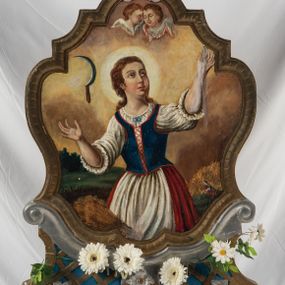 Zdjęcie nr 1: Feretron na podstawie ozdobionej kratką regencyjną, w profilowanej ramie o falistym wykroju zwieńczonej liściem akantu. Struktura obramienia jest w kolorze niebieskim oraz złocona i srebrzona. Na awersie św. Notburga ukazana w stroju służącej: długiej biało-czerwonej sukni i niebieskim gorsecie, zwrócona w lewo, ze wzrokiem skierowanym ku górze. Twarz pełna, wyraziste rysy i podbródek. Długie, jasnobrązowe, zebrane do tyłu włosy opadają na plecy. Święta wznosi do góry zgięte w łokciach ręce. U dołu, po lewej stronie kompozycji snopek zboża, natomiast w prawym dolnym rogu święta ukazana przy pracy w polu. W tle pejzaż wiejski z obniżoną linią horyzontu i niebem w odcieniach żółci i pomarańczy. Po lewej stronie kompozycji, na wysokosci głowy świętej sierp unoszący się w powietrzu, u góry para uskrzydlonych główek anielskich. Na rewersie feretronu wizerunek św. Tekli ukazanej w półpostaci, frontalnie z głową skierowaną w prawo. Twarz pełna, nos prosty, wargi pełne, oczy szeroko otwarte; włosy kręcone, jasne, długie, z wplecionymi sznurami pereł. Święta ubrana jest w dwie suknie – spodnią białą, wierzchnią niebieską, złoty gorset i czerwony płaszcz. W prawej, uniesionej ręce trzyma krzyż, lewą rękę, w której trzyma liść palmy przyciska do piersi. 

W górnej partii obrazu napis czarną farbą „Sw(ięta) Tekla P(anna) i Męcz(ennica)”.