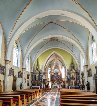 Zdjęcie nr 4: Neogotycki, murowany kościół św. Andrzeja Apostoła w Osieku jest pięcioprzęsłową świątynią salową z wyodrębnionym, trójbocznie zamkniętym prezbiterium od północy i czworoboczną wieżą od południa. Od zachodu do prezbiterium i nawy przylega zakrystia z przedsionkiem, a od wschodu czworoboczna kaplica Najświętszego Serca Pana Jezusa. Ściany elewacji zewnętrznych artykułują wysokie przypory wyznaczające przęsła, licowane czerwoną i żółtą cegłą, układaną we wzór ornamentalny. Każde z przęseł przeprute jest dużym, ostrołukowym oknem, dekorowanym przy ostrołuku ceglaną opaską. Górne odcinki pomiędzy przyporami zdobi poziomy, ceglany fryz kostkowy, zaś pod dachem ceglany gzyms koronujący. Elewacja południowa z wieżą jest trójosiowa. Oś środkową wyznacza dwupoziomowa, czworoboczna wieża wchodząca w ostatnie przęsło nawy. Flankują ją wysokie przypory podobnie jak na elewacjach bocznych licowane czerwoną i żółtą cegłą. Pierwszy poziom dekoruje rozbudowany, ceglany, ostrołukowy portal, ponad którym przepruto ostrołukowe okno. Ponad oknem z ceglaną opaską przy ostrołuku, schodzącą na poziomy, ceglany fryz kostkowy znajduje się okulus z maswerkiem z motywem rybiego pęcherza. W portalu mocno zaakcentowano ostrołukowy tympanon wypełniony maswerkiem ze sztucznego kamienia z motywami czteroliścia. Wieżę wieńczy ostrosłupowy hełm z krzyżem, pokryty blachą miedzianą, oparty na zmniejszonym, czworobocznym piętrze dzwonniczym tworzącym jej drugi poziom. W jego narożach usytuowano ceglane przypory ze sterczynami, zaś ściany boczne przepruto ostrołukowym oknem z ceglaną opaską przy ostrołuku, wypełnionym drewnianą żaluzją, wieńcząc je trójkątnymi szczytami ze sterczynami. Pole trójkątnych szczytów zawierają okrągłe tarcze zegarowe. Osie boczne elewacji wyznaczają podłużne, ostrołukowe okna z ceglanymi opaskami na wysokości ostrołuku oraz umieszczone poniżej mniejsze ostrołukowe okna doświetlające przyziemię z klatką schodową i nawę od zachodu. Wnętrze zostało nakryte sklepieniem krzyżowym. Kolejne przęsła rozdzielają ostrołukowe gurty spływające na przyścienne półfilary ustawione na cokołach i zwieńczone fazowanymi opaskami. Niższe, jednoprzęsłowe prezbiterium oddziela od nawy ostrołukowy łuk tęczowy. Przylegająca do prezbiterium od wschodu kaplica także otwiera się do wnętrze kościoła ostrołukową arkadą. W drugim przęśle usytuowano naprzeciw siebie ostrołukowe drzwi boczne. W prezbiterium ustawiono ołtarz główny, a po obu stronach łuku tęczowego dwa ołtarze boczne. Na zachodniej ścianie prezbiterium przy tęczy zawieszono ambonę. Także w kaplicy bocznej ustawiono nastawę ołtarzową. Nawę wypełniają dwa rzędy drewnianych ławek oraz dwa konfesjonały. W ostatnim przęśle, po obu stronach wchodzącej w nie wieży, urządzono chór muzyczny, na który prowadzi klatka schodowa z wejściem w przyziemiu wieży. Chór wsparto na trzech ostrołukowych arkadach. Podłogę w nawie i prezbiterium wyłożono posadzką z kolorowego granitu.   