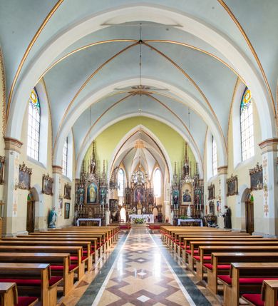 Zdjęcie nr 9: Neogotycki, murowany kościół św. Andrzeja Apostoła w Osieku jest pięcioprzęsłową świątynią salową z wyodrębnionym, trójbocznie zamkniętym prezbiterium od północy i czworoboczną wieżą od południa. Od zachodu do prezbiterium i nawy przylega zakrystia z przedsionkiem, a od wschodu czworoboczna kaplica Najświętszego Serca Pana Jezusa. Ściany elewacji zewnętrznych artykułują wysokie przypory wyznaczające przęsła, licowane czerwoną i żółtą cegłą, układaną we wzór ornamentalny. Każde z przęseł przeprute jest dużym, ostrołukowym oknem, dekorowanym przy ostrołuku ceglaną opaską. Górne odcinki pomiędzy przyporami zdobi poziomy, ceglany fryz kostkowy, zaś pod dachem ceglany gzyms koronujący. Elewacja południowa z wieżą jest trójosiowa. Oś środkową wyznacza dwupoziomowa, czworoboczna wieża wchodząca w ostatnie przęsło nawy. Flankują ją wysokie przypory podobnie jak na elewacjach bocznych licowane czerwoną i żółtą cegłą. Pierwszy poziom dekoruje rozbudowany, ceglany, ostrołukowy portal, ponad którym przepruto ostrołukowe okno. Ponad oknem z ceglaną opaską przy ostrołuku, schodzącą na poziomy, ceglany fryz kostkowy znajduje się okulus z maswerkiem z motywem rybiego pęcherza. W portalu mocno zaakcentowano ostrołukowy tympanon wypełniony maswerkiem ze sztucznego kamienia z motywami czteroliścia. Wieżę wieńczy ostrosłupowy hełm z krzyżem, pokryty blachą miedzianą, oparty na zmniejszonym, czworobocznym piętrze dzwonniczym tworzącym jej drugi poziom. W jego narożach usytuowano ceglane przypory ze sterczynami, zaś ściany boczne przepruto ostrołukowym oknem z ceglaną opaską przy ostrołuku, wypełnionym drewnianą żaluzją, wieńcząc je trójkątnymi szczytami ze sterczynami. Pole trójkątnych szczytów zawierają okrągłe tarcze zegarowe. Osie boczne elewacji wyznaczają podłużne, ostrołukowe okna z ceglanymi opaskami na wysokości ostrołuku oraz umieszczone poniżej mniejsze ostrołukowe okna doświetlające przyziemię z klatką schodową i nawę od zachodu. Wnętrze zostało nakryte sklepieniem krzyżowym. Kolejne przęsła rozdzielają ostrołukowe gurty spływające na przyścienne półfilary ustawione na cokołach i zwieńczone fazowanymi opaskami. Niższe, jednoprzęsłowe prezbiterium oddziela od nawy ostrołukowy łuk tęczowy. Przylegająca do prezbiterium od wschodu kaplica także otwiera się do wnętrze kościoła ostrołukową arkadą. W drugim przęśle usytuowano naprzeciw siebie ostrołukowe drzwi boczne. W prezbiterium ustawiono ołtarz główny, a po obu stronach łuku tęczowego dwa ołtarze boczne. Na zachodniej ścianie prezbiterium przy tęczy zawieszono ambonę. Także w kaplicy bocznej ustawiono nastawę ołtarzową. Nawę wypełniają dwa rzędy drewnianych ławek oraz dwa konfesjonały. W ostatnim przęśle, po obu stronach wchodzącej w nie wieży, urządzono chór muzyczny, na który prowadzi klatka schodowa z wejściem w przyziemiu wieży. Chór wsparto na trzech ostrołukowych arkadach. Podłogę w nawie i prezbiterium wyłożono posadzką z kolorowego granitu.   