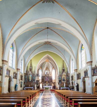 Zdjęcie nr 8: Neogotycki, murowany kościół św. Andrzeja Apostoła w Osieku jest pięcioprzęsłową świątynią salową z wyodrębnionym, trójbocznie zamkniętym prezbiterium od północy i czworoboczną wieżą od południa. Od zachodu do prezbiterium i nawy przylega zakrystia z przedsionkiem, a od wschodu czworoboczna kaplica Najświętszego Serca Pana Jezusa. Ściany elewacji zewnętrznych artykułują wysokie przypory wyznaczające przęsła, licowane czerwoną i żółtą cegłą, układaną we wzór ornamentalny. Każde z przęseł przeprute jest dużym, ostrołukowym oknem, dekorowanym przy ostrołuku ceglaną opaską. Górne odcinki pomiędzy przyporami zdobi poziomy, ceglany fryz kostkowy, zaś pod dachem ceglany gzyms koronujący. Elewacja południowa z wieżą jest trójosiowa. Oś środkową wyznacza dwupoziomowa, czworoboczna wieża wchodząca w ostatnie przęsło nawy. Flankują ją wysokie przypory podobnie jak na elewacjach bocznych licowane czerwoną i żółtą cegłą. Pierwszy poziom dekoruje rozbudowany, ceglany, ostrołukowy portal, ponad którym przepruto ostrołukowe okno. Ponad oknem z ceglaną opaską przy ostrołuku, schodzącą na poziomy, ceglany fryz kostkowy znajduje się okulus z maswerkiem z motywem rybiego pęcherza. W portalu mocno zaakcentowano ostrołukowy tympanon wypełniony maswerkiem ze sztucznego kamienia z motywami czteroliścia. Wieżę wieńczy ostrosłupowy hełm z krzyżem, pokryty blachą miedzianą, oparty na zmniejszonym, czworobocznym piętrze dzwonniczym tworzącym jej drugi poziom. W jego narożach usytuowano ceglane przypory ze sterczynami, zaś ściany boczne przepruto ostrołukowym oknem z ceglaną opaską przy ostrołuku, wypełnionym drewnianą żaluzją, wieńcząc je trójkątnymi szczytami ze sterczynami. Pole trójkątnych szczytów zawierają okrągłe tarcze zegarowe. Osie boczne elewacji wyznaczają podłużne, ostrołukowe okna z ceglanymi opaskami na wysokości ostrołuku oraz umieszczone poniżej mniejsze ostrołukowe okna doświetlające przyziemię z klatką schodową i nawę od zachodu. Wnętrze zostało nakryte sklepieniem krzyżowym. Kolejne przęsła rozdzielają ostrołukowe gurty spływające na przyścienne półfilary ustawione na cokołach i zwieńczone fazowanymi opaskami. Niższe, jednoprzęsłowe prezbiterium oddziela od nawy ostrołukowy łuk tęczowy. Przylegająca do prezbiterium od wschodu kaplica także otwiera się do wnętrze kościoła ostrołukową arkadą. W drugim przęśle usytuowano naprzeciw siebie ostrołukowe drzwi boczne. W prezbiterium ustawiono ołtarz główny, a po obu stronach łuku tęczowego dwa ołtarze boczne. Na zachodniej ścianie prezbiterium przy tęczy zawieszono ambonę. Także w kaplicy bocznej ustawiono nastawę ołtarzową. Nawę wypełniają dwa rzędy drewnianych ławek oraz dwa konfesjonały. W ostatnim przęśle, po obu stronach wchodzącej w nie wieży, urządzono chór muzyczny, na który prowadzi klatka schodowa z wejściem w przyziemiu wieży. Chór wsparto na trzech ostrołukowych arkadach. Podłogę w nawie i prezbiterium wyłożono posadzką z kolorowego granitu.   