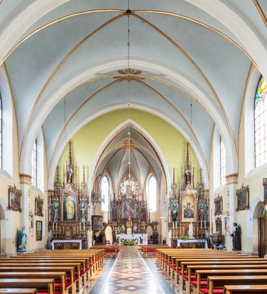 Zdjęcie nr 10: Neogotycki, murowany kościół św. Andrzeja Apostoła w Osieku jest pięcioprzęsłową świątynią salową z wyodrębnionym, trójbocznie zamkniętym prezbiterium od północy i czworoboczną wieżą od południa. Od zachodu do prezbiterium i nawy przylega zakrystia z przedsionkiem, a od wschodu czworoboczna kaplica Najświętszego Serca Pana Jezusa. Ściany elewacji zewnętrznych artykułują wysokie przypory wyznaczające przęsła, licowane czerwoną i żółtą cegłą, układaną we wzór ornamentalny. Każde z przęseł przeprute jest dużym, ostrołukowym oknem, dekorowanym przy ostrołuku ceglaną opaską. Górne odcinki pomiędzy przyporami zdobi poziomy, ceglany fryz kostkowy, zaś pod dachem ceglany gzyms koronujący. Elewacja południowa z wieżą jest trójosiowa. Oś środkową wyznacza dwupoziomowa, czworoboczna wieża wchodząca w ostatnie przęsło nawy. Flankują ją wysokie przypory podobnie jak na elewacjach bocznych licowane czerwoną i żółtą cegłą. Pierwszy poziom dekoruje rozbudowany, ceglany, ostrołukowy portal, ponad którym przepruto ostrołukowe okno. Ponad oknem z ceglaną opaską przy ostrołuku, schodzącą na poziomy, ceglany fryz kostkowy znajduje się okulus z maswerkiem z motywem rybiego pęcherza. W portalu mocno zaakcentowano ostrołukowy tympanon wypełniony maswerkiem ze sztucznego kamienia z motywami czteroliścia. Wieżę wieńczy ostrosłupowy hełm z krzyżem, pokryty blachą miedzianą, oparty na zmniejszonym, czworobocznym piętrze dzwonniczym tworzącym jej drugi poziom. W jego narożach usytuowano ceglane przypory ze sterczynami, zaś ściany boczne przepruto ostrołukowym oknem z ceglaną opaską przy ostrołuku, wypełnionym drewnianą żaluzją, wieńcząc je trójkątnymi szczytami ze sterczynami. Pole trójkątnych szczytów zawierają okrągłe tarcze zegarowe. Osie boczne elewacji wyznaczają podłużne, ostrołukowe okna z ceglanymi opaskami na wysokości ostrołuku oraz umieszczone poniżej mniejsze ostrołukowe okna doświetlające przyziemię z klatką schodową i nawę od zachodu. Wnętrze zostało nakryte sklepieniem krzyżowym. Kolejne przęsła rozdzielają ostrołukowe gurty spływające na przyścienne półfilary ustawione na cokołach i zwieńczone fazowanymi opaskami. Niższe, jednoprzęsłowe prezbiterium oddziela od nawy ostrołukowy łuk tęczowy. Przylegająca do prezbiterium od wschodu kaplica także otwiera się do wnętrze kościoła ostrołukową arkadą. W drugim przęśle usytuowano naprzeciw siebie ostrołukowe drzwi boczne. W prezbiterium ustawiono ołtarz główny, a po obu stronach łuku tęczowego dwa ołtarze boczne. Na zachodniej ścianie prezbiterium przy tęczy zawieszono ambonę. Także w kaplicy bocznej ustawiono nastawę ołtarzową. Nawę wypełniają dwa rzędy drewnianych ławek oraz dwa konfesjonały. W ostatnim przęśle, po obu stronach wchodzącej w nie wieży, urządzono chór muzyczny, na który prowadzi klatka schodowa z wejściem w przyziemiu wieży. Chór wsparto na trzech ostrołukowych arkadach. Podłogę w nawie i prezbiterium wyłożono posadzką z kolorowego granitu.   