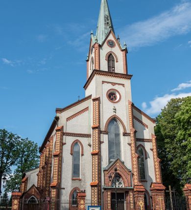 Zdjęcie nr 3: Neogotycki, murowany kościół św. Andrzeja Apostoła w Osieku jest pięcioprzęsłową świątynią salową z wyodrębnionym, trójbocznie zamkniętym prezbiterium od północy i czworoboczną wieżą od południa. Od zachodu do prezbiterium i nawy przylega zakrystia z przedsionkiem, a od wschodu czworoboczna kaplica Najświętszego Serca Pana Jezusa. Ściany elewacji zewnętrznych artykułują wysokie przypory wyznaczające przęsła, licowane czerwoną i żółtą cegłą, układaną we wzór ornamentalny. Każde z przęseł przeprute jest dużym, ostrołukowym oknem, dekorowanym przy ostrołuku ceglaną opaską. Górne odcinki pomiędzy przyporami zdobi poziomy, ceglany fryz kostkowy, zaś pod dachem ceglany gzyms koronujący. Elewacja południowa z wieżą jest trójosiowa. Oś środkową wyznacza dwupoziomowa, czworoboczna wieża wchodząca w ostatnie przęsło nawy. Flankują ją wysokie przypory podobnie jak na elewacjach bocznych licowane czerwoną i żółtą cegłą. Pierwszy poziom dekoruje rozbudowany, ceglany, ostrołukowy portal, ponad którym przepruto ostrołukowe okno. Ponad oknem z ceglaną opaską przy ostrołuku, schodzącą na poziomy, ceglany fryz kostkowy znajduje się okulus z maswerkiem z motywem rybiego pęcherza. W portalu mocno zaakcentowano ostrołukowy tympanon wypełniony maswerkiem ze sztucznego kamienia z motywami czteroliścia. Wieżę wieńczy ostrosłupowy hełm z krzyżem, pokryty blachą miedzianą, oparty na zmniejszonym, czworobocznym piętrze dzwonniczym tworzącym jej drugi poziom. W jego narożach usytuowano ceglane przypory ze sterczynami, zaś ściany boczne przepruto ostrołukowym oknem z ceglaną opaską przy ostrołuku, wypełnionym drewnianą żaluzją, wieńcząc je trójkątnymi szczytami ze sterczynami. Pole trójkątnych szczytów zawierają okrągłe tarcze zegarowe. Osie boczne elewacji wyznaczają podłużne, ostrołukowe okna z ceglanymi opaskami na wysokości ostrołuku oraz umieszczone poniżej mniejsze ostrołukowe okna doświetlające przyziemię z klatką schodową i nawę od zachodu. Wnętrze zostało nakryte sklepieniem krzyżowym. Kolejne przęsła rozdzielają ostrołukowe gurty spływające na przyścienne półfilary ustawione na cokołach i zwieńczone fazowanymi opaskami. Niższe, jednoprzęsłowe prezbiterium oddziela od nawy ostrołukowy łuk tęczowy. Przylegająca do prezbiterium od wschodu kaplica także otwiera się do wnętrze kościoła ostrołukową arkadą. W drugim przęśle usytuowano naprzeciw siebie ostrołukowe drzwi boczne. W prezbiterium ustawiono ołtarz główny, a po obu stronach łuku tęczowego dwa ołtarze boczne. Na zachodniej ścianie prezbiterium przy tęczy zawieszono ambonę. Także w kaplicy bocznej ustawiono nastawę ołtarzową. Nawę wypełniają dwa rzędy drewnianych ławek oraz dwa konfesjonały. W ostatnim przęśle, po obu stronach wchodzącej w nie wieży, urządzono chór muzyczny, na który prowadzi klatka schodowa z wejściem w przyziemiu wieży. Chór wsparto na trzech ostrołukowych arkadach. Podłogę w nawie i prezbiterium wyłożono posadzką z kolorowego granitu.   