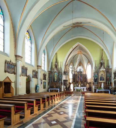 Zdjęcie nr 19: Neogotycki, murowany kościół św. Andrzeja Apostoła w Osieku jest pięcioprzęsłową świątynią salową z wyodrębnionym, trójbocznie zamkniętym prezbiterium od północy i czworoboczną wieżą od południa. Od zachodu do prezbiterium i nawy przylega zakrystia z przedsionkiem, a od wschodu czworoboczna kaplica Najświętszego Serca Pana Jezusa. Ściany elewacji zewnętrznych artykułują wysokie przypory wyznaczające przęsła, licowane czerwoną i żółtą cegłą, układaną we wzór ornamentalny. Każde z przęseł przeprute jest dużym, ostrołukowym oknem, dekorowanym przy ostrołuku ceglaną opaską. Górne odcinki pomiędzy przyporami zdobi poziomy, ceglany fryz kostkowy, zaś pod dachem ceglany gzyms koronujący. Elewacja południowa z wieżą jest trójosiowa. Oś środkową wyznacza dwupoziomowa, czworoboczna wieża wchodząca w ostatnie przęsło nawy. Flankują ją wysokie przypory podobnie jak na elewacjach bocznych licowane czerwoną i żółtą cegłą. Pierwszy poziom dekoruje rozbudowany, ceglany, ostrołukowy portal, ponad którym przepruto ostrołukowe okno. Ponad oknem z ceglaną opaską przy ostrołuku, schodzącą na poziomy, ceglany fryz kostkowy znajduje się okulus z maswerkiem z motywem rybiego pęcherza. W portalu mocno zaakcentowano ostrołukowy tympanon wypełniony maswerkiem ze sztucznego kamienia z motywami czteroliścia. Wieżę wieńczy ostrosłupowy hełm z krzyżem, pokryty blachą miedzianą, oparty na zmniejszonym, czworobocznym piętrze dzwonniczym tworzącym jej drugi poziom. W jego narożach usytuowano ceglane przypory ze sterczynami, zaś ściany boczne przepruto ostrołukowym oknem z ceglaną opaską przy ostrołuku, wypełnionym drewnianą żaluzją, wieńcząc je trójkątnymi szczytami ze sterczynami. Pole trójkątnych szczytów zawierają okrągłe tarcze zegarowe. Osie boczne elewacji wyznaczają podłużne, ostrołukowe okna z ceglanymi opaskami na wysokości ostrołuku oraz umieszczone poniżej mniejsze ostrołukowe okna doświetlające przyziemię z klatką schodową i nawę od zachodu. Wnętrze zostało nakryte sklepieniem krzyżowym. Kolejne przęsła rozdzielają ostrołukowe gurty spływające na przyścienne półfilary ustawione na cokołach i zwieńczone fazowanymi opaskami. Niższe, jednoprzęsłowe prezbiterium oddziela od nawy ostrołukowy łuk tęczowy. Przylegająca do prezbiterium od wschodu kaplica także otwiera się do wnętrze kościoła ostrołukową arkadą. W drugim przęśle usytuowano naprzeciw siebie ostrołukowe drzwi boczne. W prezbiterium ustawiono ołtarz główny, a po obu stronach łuku tęczowego dwa ołtarze boczne. Na zachodniej ścianie prezbiterium przy tęczy zawieszono ambonę. Także w kaplicy bocznej ustawiono nastawę ołtarzową. Nawę wypełniają dwa rzędy drewnianych ławek oraz dwa konfesjonały. W ostatnim przęśle, po obu stronach wchodzącej w nie wieży, urządzono chór muzyczny, na który prowadzi klatka schodowa z wejściem w przyziemiu wieży. Chór wsparto na trzech ostrołukowych arkadach. Podłogę w nawie i prezbiterium wyłożono posadzką z kolorowego granitu.   