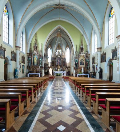 Zdjęcie nr 21: Neogotycki, murowany kościół św. Andrzeja Apostoła w Osieku jest pięcioprzęsłową świątynią salową z wyodrębnionym, trójbocznie zamkniętym prezbiterium od północy i czworoboczną wieżą od południa. Od zachodu do prezbiterium i nawy przylega zakrystia z przedsionkiem, a od wschodu czworoboczna kaplica Najświętszego Serca Pana Jezusa. Ściany elewacji zewnętrznych artykułują wysokie przypory wyznaczające przęsła, licowane czerwoną i żółtą cegłą, układaną we wzór ornamentalny. Każde z przęseł przeprute jest dużym, ostrołukowym oknem, dekorowanym przy ostrołuku ceglaną opaską. Górne odcinki pomiędzy przyporami zdobi poziomy, ceglany fryz kostkowy, zaś pod dachem ceglany gzyms koronujący. Elewacja południowa z wieżą jest trójosiowa. Oś środkową wyznacza dwupoziomowa, czworoboczna wieża wchodząca w ostatnie przęsło nawy. Flankują ją wysokie przypory podobnie jak na elewacjach bocznych licowane czerwoną i żółtą cegłą. Pierwszy poziom dekoruje rozbudowany, ceglany, ostrołukowy portal, ponad którym przepruto ostrołukowe okno. Ponad oknem z ceglaną opaską przy ostrołuku, schodzącą na poziomy, ceglany fryz kostkowy znajduje się okulus z maswerkiem z motywem rybiego pęcherza. W portalu mocno zaakcentowano ostrołukowy tympanon wypełniony maswerkiem ze sztucznego kamienia z motywami czteroliścia. Wieżę wieńczy ostrosłupowy hełm z krzyżem, pokryty blachą miedzianą, oparty na zmniejszonym, czworobocznym piętrze dzwonniczym tworzącym jej drugi poziom. W jego narożach usytuowano ceglane przypory ze sterczynami, zaś ściany boczne przepruto ostrołukowym oknem z ceglaną opaską przy ostrołuku, wypełnionym drewnianą żaluzją, wieńcząc je trójkątnymi szczytami ze sterczynami. Pole trójkątnych szczytów zawierają okrągłe tarcze zegarowe. Osie boczne elewacji wyznaczają podłużne, ostrołukowe okna z ceglanymi opaskami na wysokości ostrołuku oraz umieszczone poniżej mniejsze ostrołukowe okna doświetlające przyziemię z klatką schodową i nawę od zachodu. Wnętrze zostało nakryte sklepieniem krzyżowym. Kolejne przęsła rozdzielają ostrołukowe gurty spływające na przyścienne półfilary ustawione na cokołach i zwieńczone fazowanymi opaskami. Niższe, jednoprzęsłowe prezbiterium oddziela od nawy ostrołukowy łuk tęczowy. Przylegająca do prezbiterium od wschodu kaplica także otwiera się do wnętrze kościoła ostrołukową arkadą. W drugim przęśle usytuowano naprzeciw siebie ostrołukowe drzwi boczne. W prezbiterium ustawiono ołtarz główny, a po obu stronach łuku tęczowego dwa ołtarze boczne. Na zachodniej ścianie prezbiterium przy tęczy zawieszono ambonę. Także w kaplicy bocznej ustawiono nastawę ołtarzową. Nawę wypełniają dwa rzędy drewnianych ławek oraz dwa konfesjonały. W ostatnim przęśle, po obu stronach wchodzącej w nie wieży, urządzono chór muzyczny, na który prowadzi klatka schodowa z wejściem w przyziemiu wieży. Chór wsparto na trzech ostrołukowych arkadach. Podłogę w nawie i prezbiterium wyłożono posadzką z kolorowego granitu.   