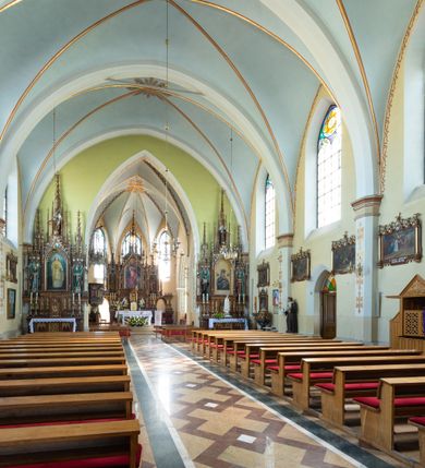 Zdjęcie nr 22: Neogotycki, murowany kościół św. Andrzeja Apostoła w Osieku jest pięcioprzęsłową świątynią salową z wyodrębnionym, trójbocznie zamkniętym prezbiterium od północy i czworoboczną wieżą od południa. Od zachodu do prezbiterium i nawy przylega zakrystia z przedsionkiem, a od wschodu czworoboczna kaplica Najświętszego Serca Pana Jezusa. Ściany elewacji zewnętrznych artykułują wysokie przypory wyznaczające przęsła, licowane czerwoną i żółtą cegłą, układaną we wzór ornamentalny. Każde z przęseł przeprute jest dużym, ostrołukowym oknem, dekorowanym przy ostrołuku ceglaną opaską. Górne odcinki pomiędzy przyporami zdobi poziomy, ceglany fryz kostkowy, zaś pod dachem ceglany gzyms koronujący. Elewacja południowa z wieżą jest trójosiowa. Oś środkową wyznacza dwupoziomowa, czworoboczna wieża wchodząca w ostatnie przęsło nawy. Flankują ją wysokie przypory podobnie jak na elewacjach bocznych licowane czerwoną i żółtą cegłą. Pierwszy poziom dekoruje rozbudowany, ceglany, ostrołukowy portal, ponad którym przepruto ostrołukowe okno. Ponad oknem z ceglaną opaską przy ostrołuku, schodzącą na poziomy, ceglany fryz kostkowy znajduje się okulus z maswerkiem z motywem rybiego pęcherza. W portalu mocno zaakcentowano ostrołukowy tympanon wypełniony maswerkiem ze sztucznego kamienia z motywami czteroliścia. Wieżę wieńczy ostrosłupowy hełm z krzyżem, pokryty blachą miedzianą, oparty na zmniejszonym, czworobocznym piętrze dzwonniczym tworzącym jej drugi poziom. W jego narożach usytuowano ceglane przypory ze sterczynami, zaś ściany boczne przepruto ostrołukowym oknem z ceglaną opaską przy ostrołuku, wypełnionym drewnianą żaluzją, wieńcząc je trójkątnymi szczytami ze sterczynami. Pole trójkątnych szczytów zawierają okrągłe tarcze zegarowe. Osie boczne elewacji wyznaczają podłużne, ostrołukowe okna z ceglanymi opaskami na wysokości ostrołuku oraz umieszczone poniżej mniejsze ostrołukowe okna doświetlające przyziemię z klatką schodową i nawę od zachodu. Wnętrze zostało nakryte sklepieniem krzyżowym. Kolejne przęsła rozdzielają ostrołukowe gurty spływające na przyścienne półfilary ustawione na cokołach i zwieńczone fazowanymi opaskami. Niższe, jednoprzęsłowe prezbiterium oddziela od nawy ostrołukowy łuk tęczowy. Przylegająca do prezbiterium od wschodu kaplica także otwiera się do wnętrze kościoła ostrołukową arkadą. W drugim przęśle usytuowano naprzeciw siebie ostrołukowe drzwi boczne. W prezbiterium ustawiono ołtarz główny, a po obu stronach łuku tęczowego dwa ołtarze boczne. Na zachodniej ścianie prezbiterium przy tęczy zawieszono ambonę. Także w kaplicy bocznej ustawiono nastawę ołtarzową. Nawę wypełniają dwa rzędy drewnianych ławek oraz dwa konfesjonały. W ostatnim przęśle, po obu stronach wchodzącej w nie wieży, urządzono chór muzyczny, na który prowadzi klatka schodowa z wejściem w przyziemiu wieży. Chór wsparto na trzech ostrołukowych arkadach. Podłogę w nawie i prezbiterium wyłożono posadzką z kolorowego granitu.   