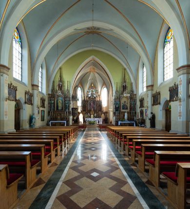 Zdjęcie nr 31: Neogotycki, murowany kościół św. Andrzeja Apostoła w Osieku jest pięcioprzęsłową świątynią salową z wyodrębnionym, trójbocznie zamkniętym prezbiterium od północy i czworoboczną wieżą od południa. Od zachodu do prezbiterium i nawy przylega zakrystia z przedsionkiem, a od wschodu czworoboczna kaplica Najświętszego Serca Pana Jezusa. Ściany elewacji zewnętrznych artykułują wysokie przypory wyznaczające przęsła, licowane czerwoną i żółtą cegłą, układaną we wzór ornamentalny. Każde z przęseł przeprute jest dużym, ostrołukowym oknem, dekorowanym przy ostrołuku ceglaną opaską. Górne odcinki pomiędzy przyporami zdobi poziomy, ceglany fryz kostkowy, zaś pod dachem ceglany gzyms koronujący. Elewacja południowa z wieżą jest trójosiowa. Oś środkową wyznacza dwupoziomowa, czworoboczna wieża wchodząca w ostatnie przęsło nawy. Flankują ją wysokie przypory podobnie jak na elewacjach bocznych licowane czerwoną i żółtą cegłą. Pierwszy poziom dekoruje rozbudowany, ceglany, ostrołukowy portal, ponad którym przepruto ostrołukowe okno. Ponad oknem z ceglaną opaską przy ostrołuku, schodzącą na poziomy, ceglany fryz kostkowy znajduje się okulus z maswerkiem z motywem rybiego pęcherza. W portalu mocno zaakcentowano ostrołukowy tympanon wypełniony maswerkiem ze sztucznego kamienia z motywami czteroliścia. Wieżę wieńczy ostrosłupowy hełm z krzyżem, pokryty blachą miedzianą, oparty na zmniejszonym, czworobocznym piętrze dzwonniczym tworzącym jej drugi poziom. W jego narożach usytuowano ceglane przypory ze sterczynami, zaś ściany boczne przepruto ostrołukowym oknem z ceglaną opaską przy ostrołuku, wypełnionym drewnianą żaluzją, wieńcząc je trójkątnymi szczytami ze sterczynami. Pole trójkątnych szczytów zawierają okrągłe tarcze zegarowe. Osie boczne elewacji wyznaczają podłużne, ostrołukowe okna z ceglanymi opaskami na wysokości ostrołuku oraz umieszczone poniżej mniejsze ostrołukowe okna doświetlające przyziemię z klatką schodową i nawę od zachodu. Wnętrze zostało nakryte sklepieniem krzyżowym. Kolejne przęsła rozdzielają ostrołukowe gurty spływające na przyścienne półfilary ustawione na cokołach i zwieńczone fazowanymi opaskami. Niższe, jednoprzęsłowe prezbiterium oddziela od nawy ostrołukowy łuk tęczowy. Przylegająca do prezbiterium od wschodu kaplica także otwiera się do wnętrze kościoła ostrołukową arkadą. W drugim przęśle usytuowano naprzeciw siebie ostrołukowe drzwi boczne. W prezbiterium ustawiono ołtarz główny, a po obu stronach łuku tęczowego dwa ołtarze boczne. Na zachodniej ścianie prezbiterium przy tęczy zawieszono ambonę. Także w kaplicy bocznej ustawiono nastawę ołtarzową. Nawę wypełniają dwa rzędy drewnianych ławek oraz dwa konfesjonały. W ostatnim przęśle, po obu stronach wchodzącej w nie wieży, urządzono chór muzyczny, na który prowadzi klatka schodowa z wejściem w przyziemiu wieży. Chór wsparto na trzech ostrołukowych arkadach. Podłogę w nawie i prezbiterium wyłożono posadzką z kolorowego granitu.   