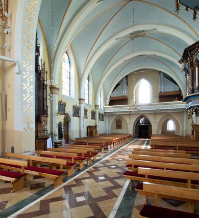 Zdjęcie nr 30: Neogotycki, murowany kościół św. Andrzeja Apostoła w Osieku jest pięcioprzęsłową świątynią salową z wyodrębnionym, trójbocznie zamkniętym prezbiterium od północy i czworoboczną wieżą od południa. Od zachodu do prezbiterium i nawy przylega zakrystia z przedsionkiem, a od wschodu czworoboczna kaplica Najświętszego Serca Pana Jezusa. Ściany elewacji zewnętrznych artykułują wysokie przypory wyznaczające przęsła, licowane czerwoną i żółtą cegłą, układaną we wzór ornamentalny. Każde z przęseł przeprute jest dużym, ostrołukowym oknem, dekorowanym przy ostrołuku ceglaną opaską. Górne odcinki pomiędzy przyporami zdobi poziomy, ceglany fryz kostkowy, zaś pod dachem ceglany gzyms koronujący. Elewacja południowa z wieżą jest trójosiowa. Oś środkową wyznacza dwupoziomowa, czworoboczna wieża wchodząca w ostatnie przęsło nawy. Flankują ją wysokie przypory podobnie jak na elewacjach bocznych licowane czerwoną i żółtą cegłą. Pierwszy poziom dekoruje rozbudowany, ceglany, ostrołukowy portal, ponad którym przepruto ostrołukowe okno. Ponad oknem z ceglaną opaską przy ostrołuku, schodzącą na poziomy, ceglany fryz kostkowy znajduje się okulus z maswerkiem z motywem rybiego pęcherza. W portalu mocno zaakcentowano ostrołukowy tympanon wypełniony maswerkiem ze sztucznego kamienia z motywami czteroliścia. Wieżę wieńczy ostrosłupowy hełm z krzyżem, pokryty blachą miedzianą, oparty na zmniejszonym, czworobocznym piętrze dzwonniczym tworzącym jej drugi poziom. W jego narożach usytuowano ceglane przypory ze sterczynami, zaś ściany boczne przepruto ostrołukowym oknem z ceglaną opaską przy ostrołuku, wypełnionym drewnianą żaluzją, wieńcząc je trójkątnymi szczytami ze sterczynami. Pole trójkątnych szczytów zawierają okrągłe tarcze zegarowe. Osie boczne elewacji wyznaczają podłużne, ostrołukowe okna z ceglanymi opaskami na wysokości ostrołuku oraz umieszczone poniżej mniejsze ostrołukowe okna doświetlające przyziemię z klatką schodową i nawę od zachodu. Wnętrze zostało nakryte sklepieniem krzyżowym. Kolejne przęsła rozdzielają ostrołukowe gurty spływające na przyścienne półfilary ustawione na cokołach i zwieńczone fazowanymi opaskami. Niższe, jednoprzęsłowe prezbiterium oddziela od nawy ostrołukowy łuk tęczowy. Przylegająca do prezbiterium od wschodu kaplica także otwiera się do wnętrze kościoła ostrołukową arkadą. W drugim przęśle usytuowano naprzeciw siebie ostrołukowe drzwi boczne. W prezbiterium ustawiono ołtarz główny, a po obu stronach łuku tęczowego dwa ołtarze boczne. Na zachodniej ścianie prezbiterium przy tęczy zawieszono ambonę. Także w kaplicy bocznej ustawiono nastawę ołtarzową. Nawę wypełniają dwa rzędy drewnianych ławek oraz dwa konfesjonały. W ostatnim przęśle, po obu stronach wchodzącej w nie wieży, urządzono chór muzyczny, na który prowadzi klatka schodowa z wejściem w przyziemiu wieży. Chór wsparto na trzech ostrołukowych arkadach. Podłogę w nawie i prezbiterium wyłożono posadzką z kolorowego granitu.   