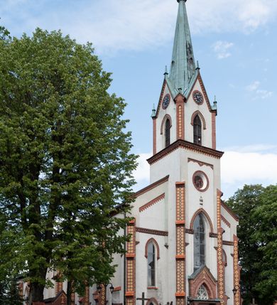 Zdjęcie nr 5: Neogotycki, murowany kościół św. Andrzeja Apostoła w Osieku jest pięcioprzęsłową świątynią salową z wyodrębnionym, trójbocznie zamkniętym prezbiterium od północy i czworoboczną wieżą od południa. Od zachodu do prezbiterium i nawy przylega zakrystia z przedsionkiem, a od wschodu czworoboczna kaplica Najświętszego Serca Pana Jezusa. Ściany elewacji zewnętrznych artykułują wysokie przypory wyznaczające przęsła, licowane czerwoną i żółtą cegłą, układaną we wzór ornamentalny. Każde z przęseł przeprute jest dużym, ostrołukowym oknem, dekorowanym przy ostrołuku ceglaną opaską. Górne odcinki pomiędzy przyporami zdobi poziomy, ceglany fryz kostkowy, zaś pod dachem ceglany gzyms koronujący. Elewacja południowa z wieżą jest trójosiowa. Oś środkową wyznacza dwupoziomowa, czworoboczna wieża wchodząca w ostatnie przęsło nawy. Flankują ją wysokie przypory podobnie jak na elewacjach bocznych licowane czerwoną i żółtą cegłą. Pierwszy poziom dekoruje rozbudowany, ceglany, ostrołukowy portal, ponad którym przepruto ostrołukowe okno. Ponad oknem z ceglaną opaską przy ostrołuku, schodzącą na poziomy, ceglany fryz kostkowy znajduje się okulus z maswerkiem z motywem rybiego pęcherza. W portalu mocno zaakcentowano ostrołukowy tympanon wypełniony maswerkiem ze sztucznego kamienia z motywami czteroliścia. Wieżę wieńczy ostrosłupowy hełm z krzyżem, pokryty blachą miedzianą, oparty na zmniejszonym, czworobocznym piętrze dzwonniczym tworzącym jej drugi poziom. W jego narożach usytuowano ceglane przypory ze sterczynami, zaś ściany boczne przepruto ostrołukowym oknem z ceglaną opaską przy ostrołuku, wypełnionym drewnianą żaluzją, wieńcząc je trójkątnymi szczytami ze sterczynami. Pole trójkątnych szczytów zawierają okrągłe tarcze zegarowe. Osie boczne elewacji wyznaczają podłużne, ostrołukowe okna z ceglanymi opaskami na wysokości ostrołuku oraz umieszczone poniżej mniejsze ostrołukowe okna doświetlające przyziemię z klatką schodową i nawę od zachodu. Wnętrze zostało nakryte sklepieniem krzyżowym. Kolejne przęsła rozdzielają ostrołukowe gurty spływające na przyścienne półfilary ustawione na cokołach i zwieńczone fazowanymi opaskami. Niższe, jednoprzęsłowe prezbiterium oddziela od nawy ostrołukowy łuk tęczowy. Przylegająca do prezbiterium od wschodu kaplica także otwiera się do wnętrze kościoła ostrołukową arkadą. W drugim przęśle usytuowano naprzeciw siebie ostrołukowe drzwi boczne. W prezbiterium ustawiono ołtarz główny, a po obu stronach łuku tęczowego dwa ołtarze boczne. Na zachodniej ścianie prezbiterium przy tęczy zawieszono ambonę. Także w kaplicy bocznej ustawiono nastawę ołtarzową. Nawę wypełniają dwa rzędy drewnianych ławek oraz dwa konfesjonały. W ostatnim przęśle, po obu stronach wchodzącej w nie wieży, urządzono chór muzyczny, na który prowadzi klatka schodowa z wejściem w przyziemiu wieży. Chór wsparto na trzech ostrołukowych arkadach. Podłogę w nawie i prezbiterium wyłożono posadzką z kolorowego granitu.   