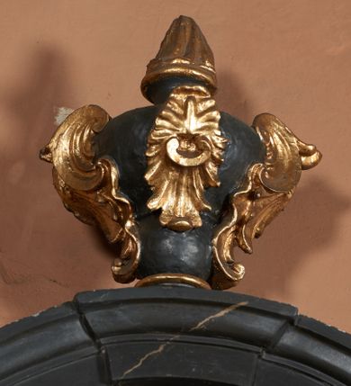 Zdjęcie nr 32: Nastawa ołtarza stiukowa, architektoniczna, jednoosiowa, jednokondygnacyjna, o wklęsłym licu, ze zwieńczeniem oraz osadzona na wysokim cokole. Ołtarz drewniany, sarkofagowy z drewnianą, silnie wysuniętą mensą. Retabulum ujęte jest parą zdwojonych pilastrów o trzonach dekorowanych konsolkami i kampanulami na froncie, dźwigających przerwane belkowanie. W polu środkowym umieszczono obraz św. Mikołaja ujęty profilowaną ramą w formie stojącego prostokąta zamkniętego łukiem odcinkowym, nadwieszonym z uskokiem i uszakami po bokach, wklęsłego u spodu. Poniżej obrazu znajduje się płycina ujęta spływami wolutowymi, zamknięta fragmentem gzymsu w formie łuku odcinkowego. W jej polu jest kartusz o fantazyjnym wykroju. Zwieńczenie ujęto parą spływów wolutowych i zamknięto fragmentem wklęsło-wypukłego gzymsu, na którym jest płomienisty wazon. Na końcach spływów wolutowych znajduje się para siedzących putt.  
Pole zwieńczenia wypełniają płaskorzeźbione obłoki z uskrzydlonymi główkami anielskimi oraz ukazana na ich tle promienista gloria z monogramem maryjnym pośrodku. Struktura retabulum jest marmoryzowana w kolorze szaro-brązowym i ciemnoszarym, ze złoconymi i srebrzonymi detalami.
