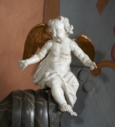Zdjęcie nr 9: Nastawa ołtarza stiukowa, architektoniczna, jednoosiowa, jednokondygnacyjna, o wklęsłym licu, ze zwieńczeniem oraz osadzona na wysokim cokole. Ołtarz drewniany, sarkofagowy z drewnianą, silnie wysuniętą mensą. Retabulum ujęte jest parą zdwojonych pilastrów o trzonach dekorowanych konsolkami i kampanulami na froncie, dźwigających przerwane belkowanie. W polu środkowym umieszczono obraz św. Mikołaja ujęty profilowaną ramą w formie stojącego prostokąta zamkniętego łukiem odcinkowym, nadwieszonym z uskokiem i uszakami po bokach, wklęsłego u spodu. Poniżej obrazu znajduje się płycina ujęta spływami wolutowymi, zamknięta fragmentem gzymsu w formie łuku odcinkowego. W jej polu jest kartusz o fantazyjnym wykroju. Zwieńczenie ujęto parą spływów wolutowych i zamknięto fragmentem wklęsło-wypukłego gzymsu, na którym jest płomienisty wazon. Na końcach spływów wolutowych znajduje się para siedzących putt.  
Pole zwieńczenia wypełniają płaskorzeźbione obłoki z uskrzydlonymi główkami anielskimi oraz ukazana na ich tle promienista gloria z monogramem maryjnym pośrodku. Struktura retabulum jest marmoryzowana w kolorze szaro-brązowym i ciemnoszarym, ze złoconymi i srebrzonymi detalami.
