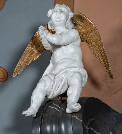 Zdjęcie nr 6: Nastawa ołtarza stiukowa, architektoniczna, jednoosiowa, jednokondygnacyjna, o wklęsłym licu, ze zwieńczeniem oraz osadzona na wysokim cokole. Ołtarz drewniany, sarkofagowy z drewnianą, silnie wysuniętą mensą. Retabulum ujęte jest parą zdwojonych pilastrów o trzonach dekorowanych konsolkami i kampanulami na froncie, dźwigających przerwane belkowanie. W polu środkowym umieszczono obraz św. Mikołaja ujęty profilowaną ramą w formie stojącego prostokąta zamkniętego łukiem odcinkowym, nadwieszonym z uskokiem i uszakami po bokach, wklęsłego u spodu. Poniżej obrazu znajduje się płycina ujęta spływami wolutowymi, zamknięta fragmentem gzymsu w formie łuku odcinkowego. W jej polu jest kartusz o fantazyjnym wykroju. Zwieńczenie ujęto parą spływów wolutowych i zamknięto fragmentem wklęsło-wypukłego gzymsu, na którym jest płomienisty wazon. Na końcach spływów wolutowych znajduje się para siedzących putt.  
Pole zwieńczenia wypełniają płaskorzeźbione obłoki z uskrzydlonymi główkami anielskimi oraz ukazana na ich tle promienista gloria z monogramem maryjnym pośrodku. Struktura retabulum jest marmoryzowana w kolorze szaro-brązowym i ciemnoszarym, ze złoconymi i srebrzonymi detalami.
