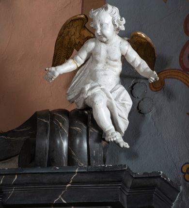 Zdjęcie nr 8: Nastawa ołtarza stiukowa, architektoniczna, jednoosiowa, jednokondygnacyjna, o wklęsłym licu, ze zwieńczeniem oraz osadzona na wysokim cokole. Ołtarz drewniany, sarkofagowy z drewnianą, silnie wysuniętą mensą. Retabulum ujęte jest parą zdwojonych pilastrów o trzonach dekorowanych konsolkami i kampanulami na froncie, dźwigających przerwane belkowanie. W polu środkowym umieszczono obraz św. Mikołaja ujęty profilowaną ramą w formie stojącego prostokąta zamkniętego łukiem odcinkowym, nadwieszonym z uskokiem i uszakami po bokach, wklęsłego u spodu. Poniżej obrazu znajduje się płycina ujęta spływami wolutowymi, zamknięta fragmentem gzymsu w formie łuku odcinkowego. W jej polu jest kartusz o fantazyjnym wykroju. Zwieńczenie ujęto parą spływów wolutowych i zamknięto fragmentem wklęsło-wypukłego gzymsu, na którym jest płomienisty wazon. Na końcach spływów wolutowych znajduje się para siedzących putt.  
Pole zwieńczenia wypełniają płaskorzeźbione obłoki z uskrzydlonymi główkami anielskimi oraz ukazana na ich tle promienista gloria z monogramem maryjnym pośrodku. Struktura retabulum jest marmoryzowana w kolorze szaro-brązowym i ciemnoszarym, ze złoconymi i srebrzonymi detalami.
