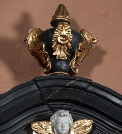 Zdjęcie nr 31: Nastawa ołtarza stiukowa, architektoniczna, jednoosiowa, jednokondygnacyjna, o wklęsłym licu, ze zwieńczeniem oraz osadzona na wysokim cokole. Ołtarz drewniany, sarkofagowy z drewnianą, silnie wysuniętą mensą. Retabulum ujęte jest parą zdwojonych pilastrów o trzonach dekorowanych konsolkami i kampanulami na froncie, dźwigających przerwane belkowanie. W polu środkowym umieszczono obraz św. Mikołaja ujęty profilowaną ramą w formie stojącego prostokąta zamkniętego łukiem odcinkowym, nadwieszonym z uskokiem i uszakami po bokach, wklęsłego u spodu. Poniżej obrazu znajduje się płycina ujęta spływami wolutowymi, zamknięta fragmentem gzymsu w formie łuku odcinkowego. W jej polu jest kartusz o fantazyjnym wykroju. Zwieńczenie ujęto parą spływów wolutowych i zamknięto fragmentem wklęsło-wypukłego gzymsu, na którym jest płomienisty wazon. Na końcach spływów wolutowych znajduje się para siedzących putt.  
Pole zwieńczenia wypełniają płaskorzeźbione obłoki z uskrzydlonymi główkami anielskimi oraz ukazana na ich tle promienista gloria z monogramem maryjnym pośrodku. Struktura retabulum jest marmoryzowana w kolorze szaro-brązowym i ciemnoszarym, ze złoconymi i srebrzonymi detalami.
