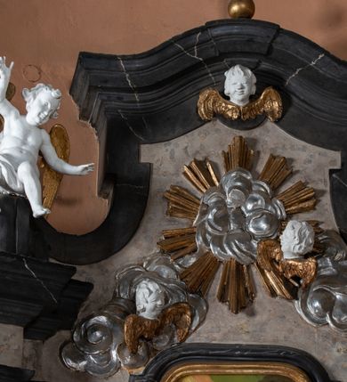 Zdjęcie nr 9: Nastawa ołtarza stiukowa, architektoniczna, jednoosiowa, jednokondygnacyjna, o wklęsłym licu, ze zwieńczeniem oraz osadzona na wysokim cokole. Ołtarz drewniany, sarkofagowy z drewnianą, silnie wysuniętą mensą. Retabulum ujęte parą zdwojonych pilastrów o trzonach dekorowanych konsolkami i kampanulami na froncie, dźwigających przerwane belkowanie. W polu środkowym umieszczono obraz św. Jana Nepomucena ujęty profilowaną ramą w formie stojącego prostokąta zamkniętego łukiem odcinkowym, nadwieszonym z uskokiem i uszakami po bokach, wklęsłego u spodu. Poniżej obrazu znajduje się płycina ujęta spływami wolutowymi, zamknięta fragmentem gzymsu w formie łuku odcinkowego. W jej polu jest kartusz o fantazyjnym wykroju. Zwieńczenie ujęto parą spływów wolutowych i zamknięto fragmentem wklęsło-wypukłego gzymsu, na którym jest krzyż na kuli. Na końcach spływów wolutowych znajduje się para siedzących putt.  
Pole zwieńczenia wypełniają płaskorzeźbione obłoki z uskrzydlonymi główkami anielskimi oraz ukazana na ich tle promienista gloria. Struktura retabulum jest marmoryzowana w kolorze szaro-brązowym i ciemnoszarym, ze złoconymi i srebrzonymi detalami.

