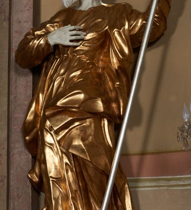 Zdjęcie nr 7: Architektoniczna nastawa ołtarzowa jest jednoosiowa, jednokondygnacyjna ze zwieńczeniem, osadzona na cokole, ujęta parą kolumn o kapitelach kompozytowych, wysuniętych przed strukturę. Każda usytuowana jest na tle pary wklęsłych, ustawionych pod kątem pilastrów, zdwojonych po zewnętrznej stronie nastawy. Kolumny i pilastry wspierają przerwane belkowanie. Pole środkowe retabulum zaaranżowane jest w formie paludamentu pod baldachimem, którego krawędź ozdobiono lambrekinem. Tkanina po bokach jest podwiązana wstęgami. Na tle paludamentu znajduje się niewielka wnęka w kształcie stojącego prostokąta, ujęta profilowaną, dekorowaną ornamentem ramą z wizerunkiem Matki Boskiej z Dzieciątkiem. Ponad obrazem umieszczono płaskorzeźbione oko Opatrzności Bożej ukazane na tle obłoków i glorii promienistej. Zwieńczenie ołtarza ujęte jest parą wolut spływających na belkowanie i zamknięte fragmentem gzymsu w formie łuku odcinkowego zakończonego wolutami. Po bokach znajduje się para adorujących aniołów. W polu zwieńczenia zlokalizowano owalny medalion z monogramem maryjnym, ujęty promienistą glorią oraz otokiem z obłoków i uskrzydlonych główek anielskich. Nastawę flankują cokoły z figurami św. Anny i św. Joachima. Struktura retabulum jest marmoryzowana w kolorze szaro-brązowym i ciemnoróżowym, detale polichromowane na biało, złocone i srebrzone.