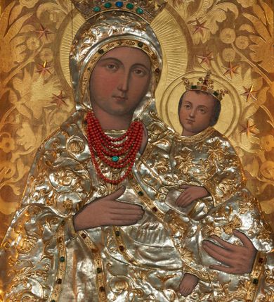 Zdjęcie nr 3: Obraz w kształcie stojącego prostokąta przedstawia Matkę Boską z Dzieciątkiem wyobrażoną w półpostaci. Sylwetka Marii nieznacznie zwrócona jest w lewo. Jej zaokrągloną twarz charakteryzują łagodne, wyraziste rysy o silnie podkreślonych liniach łuków brwiowych i prostego nosa wydobyte światłocieniem. Oczy są duże, usta drobne, a karnacja śniada. Partie szat, łącznie z maforionem zasłaniającym włosy Marii, pokryte są metalowymi, srebrzonymi sukienkami, na powierzchni których odtworzono w ogólnych zarysach przebieg fałdów; szaty zdobione są motywem stylizowanej, ukwieconej, złoconej wici roślinnej, o kameryzowanych lamówkach. Maria prawą ręką o wyprostowanych palcach wskazuje na trzymane na lewej ręce Dzieciątko, w trzech czwartych skierowane w lewo. Zwróconą niemal na wprost twarz charakteryzuje podobny jak w przypadku Marii sposób modelunku, okalają ją krótkie, brązowe włosy. Ubraną w długą tunikę sylwetkę Jezusa także osłania metalowa sukienka. Lewą ręką podtrzymuje on na kolanach księgę, prawą unosi w geście błogosławieństwa; u dołu widoczna jest nieobuta, swobodnie zwisająca stopa Dzieciątka. Postaci ukazane są na tłoczonym w gruncie, złoconym tle dekorowanym motywem roślinnym. Zwieńczone otwartymi, kameryzowanymi koronami głowy okalają nimby i wieńce z gwiazd. Wizerunek ujęty profilowaną, srebrzoną ramą zdobioną złoconymi motywami rocaille.