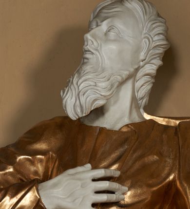 Zdjęcie nr 4: Figura ustawiona na na kwadratowej podstawie, drążona z tyłu, przedstawia stojącego św. Joachima, wyobrażonego w całej postaci. zwróconego nieznacznie w prawo, z uniesioną ku górze głową. Prawa ręka św. Joachima spoczywa na piersi, w lewej, lekko zgiętej w łokciu i odsuniętej w bok trzyma szufle pasterską. Twarz jest pociągła, wychudzona, z długim zarostem i o wyrazistych rysach z silnie uwypuklonymi kośćmi policzkowymi, liniami łuków brwiowych, wąskim nosem, małymi, rozchylonymi, pełnymi ustami z uniesioną górną wargą oraz dużymi, głęboko osadzonymi oczami spoglądającymi w górę. Krótkie, lekko falowane włosy układają się w regularne pukle. Smukłą i wydłużoną sylwetkę świętego osłania przylegająca do ciała, długa, drapowana suknia przepasana w talii oraz narzucony na plecy i opadający wzdłuż boków płaszcz z fragmentem tkaniny zasłaniającym częściowo lewe udo. Kolorystyka odsłoniętych partii ciała utrzymana jest w bieli, szaty złocone, drzewiec, na którym osadzona jest szufla srebrzony.