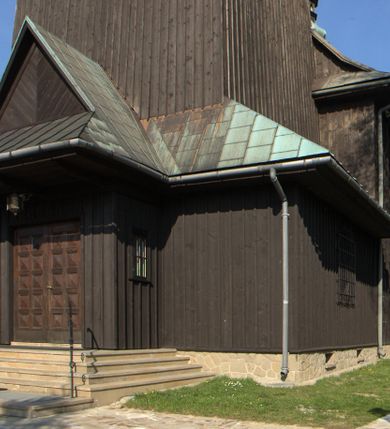 Zdjęcie nr 3: Kościół drewniany, orientowany, jednonawowy o konstrukcji zrębowej, oszalowany. Prezbiterium kwadratowe o wielobocznym zamknięciu z zakrystią od północy. Nawa szersza, prawie kwadratowa, przy niej od północy kaplica i składzik później dostawiony; od południa i od zachodu kruchty. Korpus nakryty dachem dwuspadowym, jednokalenicowym, z barokową wieżyczką na sygnaturkę na kalenicy; składzik nakryty dachem pulpitowym. Wewnątrz stropy kasetonowe. Otwór tęczy o profilowanym łuku półkolistym podwyższonym; belka profilowana, na niej grupa Ukrzyżowania. Chór muzyczny wsparty na dwóch słupach. Kaplica otwarta do nawy półkolistą arkadą. Troje drzwi o ozdobnych obramieniach uszatych, schodkowatych i uszato-schodkowatych, ze starymi okuciami. Wieża nowa, izbicowa o pochyłych ścianach, zwieńczona ostrosłupowym hełmem.
