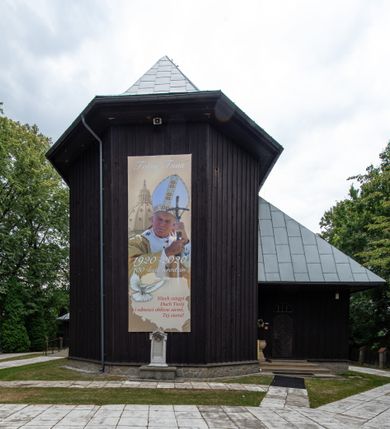 Zdjęcie nr 11: Kościół drewniany, orientowany, jednonawowy o konstrukcji zrębowej, oszalowany. Prezbiterium kwadratowe o wielobocznym zamknięciu z zakrystią od północy. Nawa szersza, prawie kwadratowa, przy niej od północy kaplica i składzik później dostawiony; od południa i od zachodu kruchty. Korpus nakryty dachem dwuspadowym, jednokalenicowym, z barokową wieżyczką na sygnaturkę na kalenicy; składzik nakryty dachem pulpitowym. Wewnątrz stropy kasetonowe. Otwór tęczy o profilowanym łuku półkolistym podwyższonym; belka profilowana, na niej grupa Ukrzyżowania. Chór muzyczny wsparty na dwóch słupach. Kaplica otwarta do nawy półkolistą arkadą. Troje drzwi o ozdobnych obramieniach uszatych, schodkowatych i uszato-schodkowatych, ze starymi okuciami. Wieża nowa, izbicowa o pochyłych ścianach, zwieńczona ostrosłupowym hełmem.
