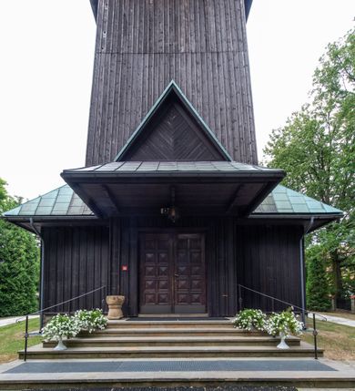 Zdjęcie nr 42: Kościół drewniany, orientowany, jednonawowy o konstrukcji zrębowej, oszalowany. Prezbiterium kwadratowe o wielobocznym zamknięciu z zakrystią od północy. Nawa szersza, prawie kwadratowa, przy niej od północy kaplica i składzik później dostawiony; od południa i od zachodu kruchty. Korpus nakryty dachem dwuspadowym, jednokalenicowym, z barokową wieżyczką na sygnaturkę na kalenicy; składzik nakryty dachem pulpitowym. Wewnątrz stropy kasetonowe. Otwór tęczy o profilowanym łuku półkolistym podwyższonym; belka profilowana, na niej grupa Ukrzyżowania. Chór muzyczny wsparty na dwóch słupach. Kaplica otwarta do nawy półkolistą arkadą. Troje drzwi o ozdobnych obramieniach uszatych, schodkowatych i uszato-schodkowatych, ze starymi okuciami. Wieża nowa, izbicowa o pochyłych ścianach, zwieńczona ostrosłupowym hełmem.
