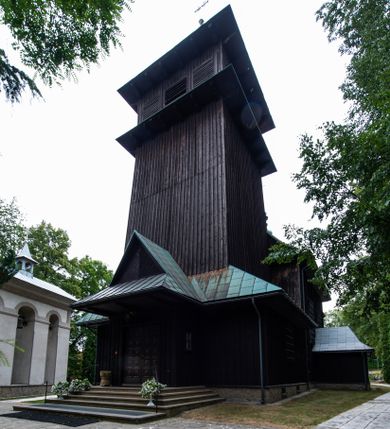 Zdjęcie nr 1: Kościół drewniany, orientowany, jednonawowy o konstrukcji zrębowej, oszalowany. Prezbiterium kwadratowe o wielobocznym zamknięciu z zakrystią od północy. Nawa szersza, prawie kwadratowa, przy niej od północy kaplica i składzik później dostawiony; od południa i od zachodu kruchty. Korpus nakryty dachem dwuspadowym, jednokalenicowym, z barokową wieżyczką na sygnaturkę na kalenicy; składzik nakryty dachem pulpitowym. Wewnątrz stropy kasetonowe. Otwór tęczy o profilowanym łuku półkolistym podwyższonym; belka profilowana, na niej grupa Ukrzyżowania. Chór muzyczny wsparty na dwóch słupach. Kaplica otwarta do nawy półkolistą arkadą. Troje drzwi o ozdobnych obramieniach uszatych, schodkowatych i uszato-schodkowatych, ze starymi okuciami. Wieża nowa, izbicowa o pochyłych ścianach, zwieńczona ostrosłupowym hełmem.
