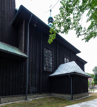 Zdjęcie nr 4: Kościół drewniany, orientowany, jednonawowy o konstrukcji zrębowej, oszalowany. Prezbiterium kwadratowe o wielobocznym zamknięciu z zakrystią od północy. Nawa szersza, prawie kwadratowa, przy niej od północy kaplica i składzik później dostawiony; od południa i od zachodu kruchty. Korpus nakryty dachem dwuspadowym, jednokalenicowym, z barokową wieżyczką na sygnaturkę na kalenicy; składzik nakryty dachem pulpitowym. Wewnątrz stropy kasetonowe. Otwór tęczy o profilowanym łuku półkolistym podwyższonym; belka profilowana, na niej grupa Ukrzyżowania. Chór muzyczny wsparty na dwóch słupach. Kaplica otwarta do nawy półkolistą arkadą. Troje drzwi o ozdobnych obramieniach uszatych, schodkowatych i uszato-schodkowatych, ze starymi okuciami. Wieża nowa, izbicowa o pochyłych ścianach, zwieńczona ostrosłupowym hełmem.

