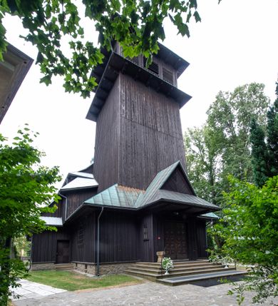 Zdjęcie nr 2: Kościół drewniany, orientowany, jednonawowy o konstrukcji zrębowej, oszalowany. Prezbiterium kwadratowe o wielobocznym zamknięciu z zakrystią od północy. Nawa szersza, prawie kwadratowa, przy niej od północy kaplica i składzik później dostawiony; od południa i od zachodu kruchty. Korpus nakryty dachem dwuspadowym, jednokalenicowym, z barokową wieżyczką na sygnaturkę na kalenicy; składzik nakryty dachem pulpitowym. Wewnątrz stropy kasetonowe. Otwór tęczy o profilowanym łuku półkolistym podwyższonym; belka profilowana, na niej grupa Ukrzyżowania. Chór muzyczny wsparty na dwóch słupach. Kaplica otwarta do nawy półkolistą arkadą. Troje drzwi o ozdobnych obramieniach uszatych, schodkowatych i uszato-schodkowatych, ze starymi okuciami. Wieża nowa, izbicowa o pochyłych ścianach, zwieńczona ostrosłupowym hełmem.
